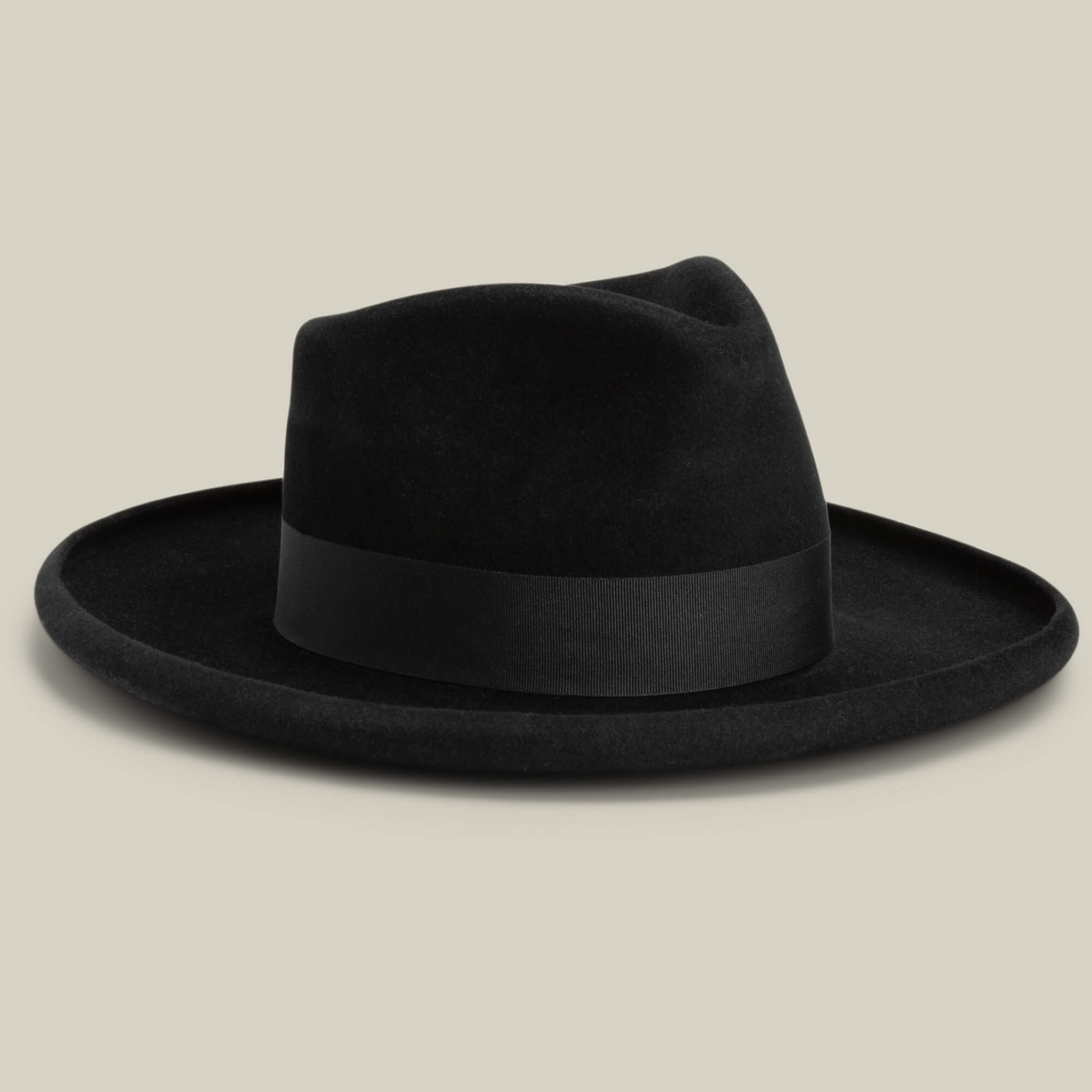 The Colonel Pierce by Goorin Bros. is a black wide-brimmed fedora featuring a pencil curl brim, teardrop crown, and black ribbon band, shown on a neutral background.