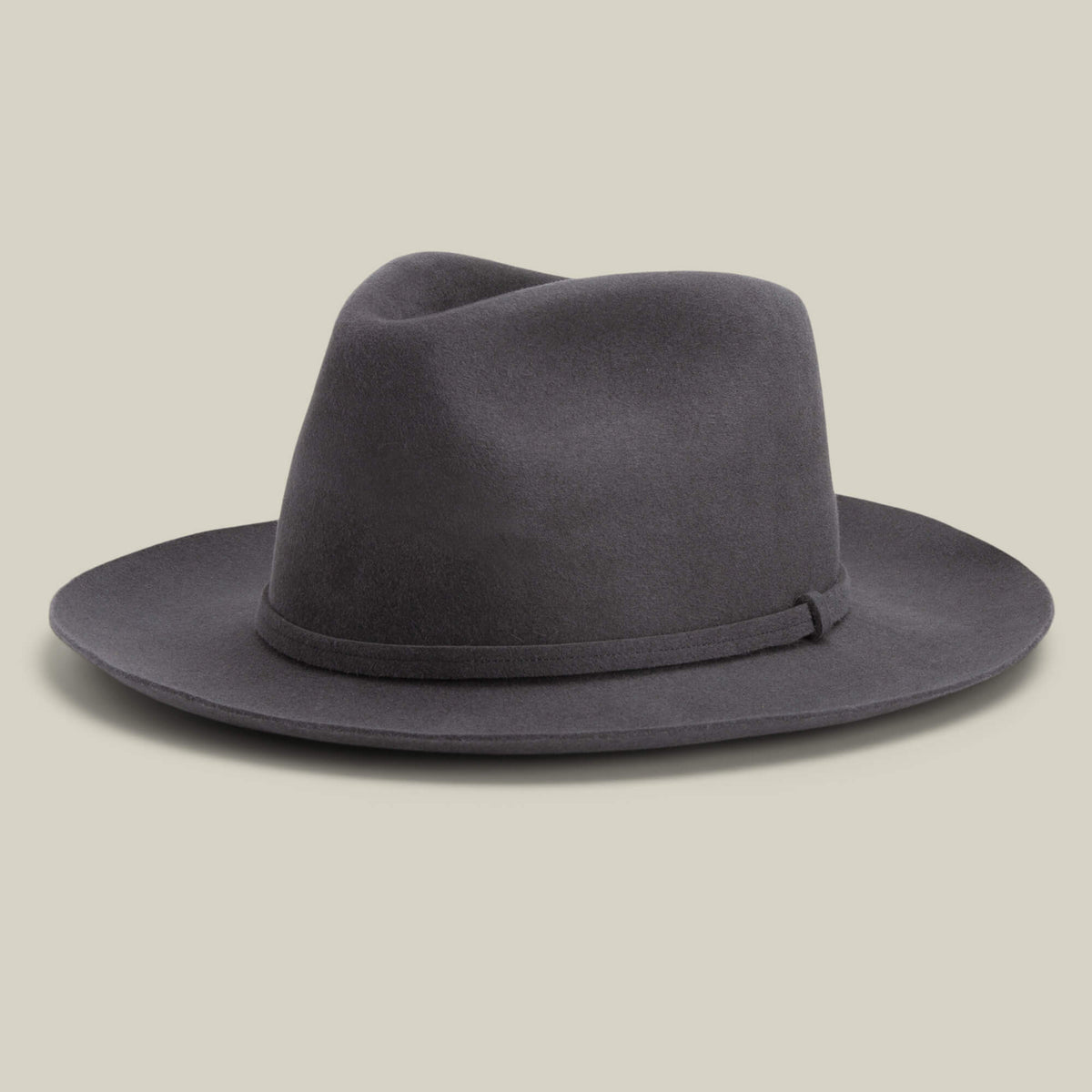The Night Hawk by Goorin Bros. is a dark gray teardrop crown fedora with a wide snap brim and matching hatband, shown on a light beige background—an all-season hat suited for any occasion.