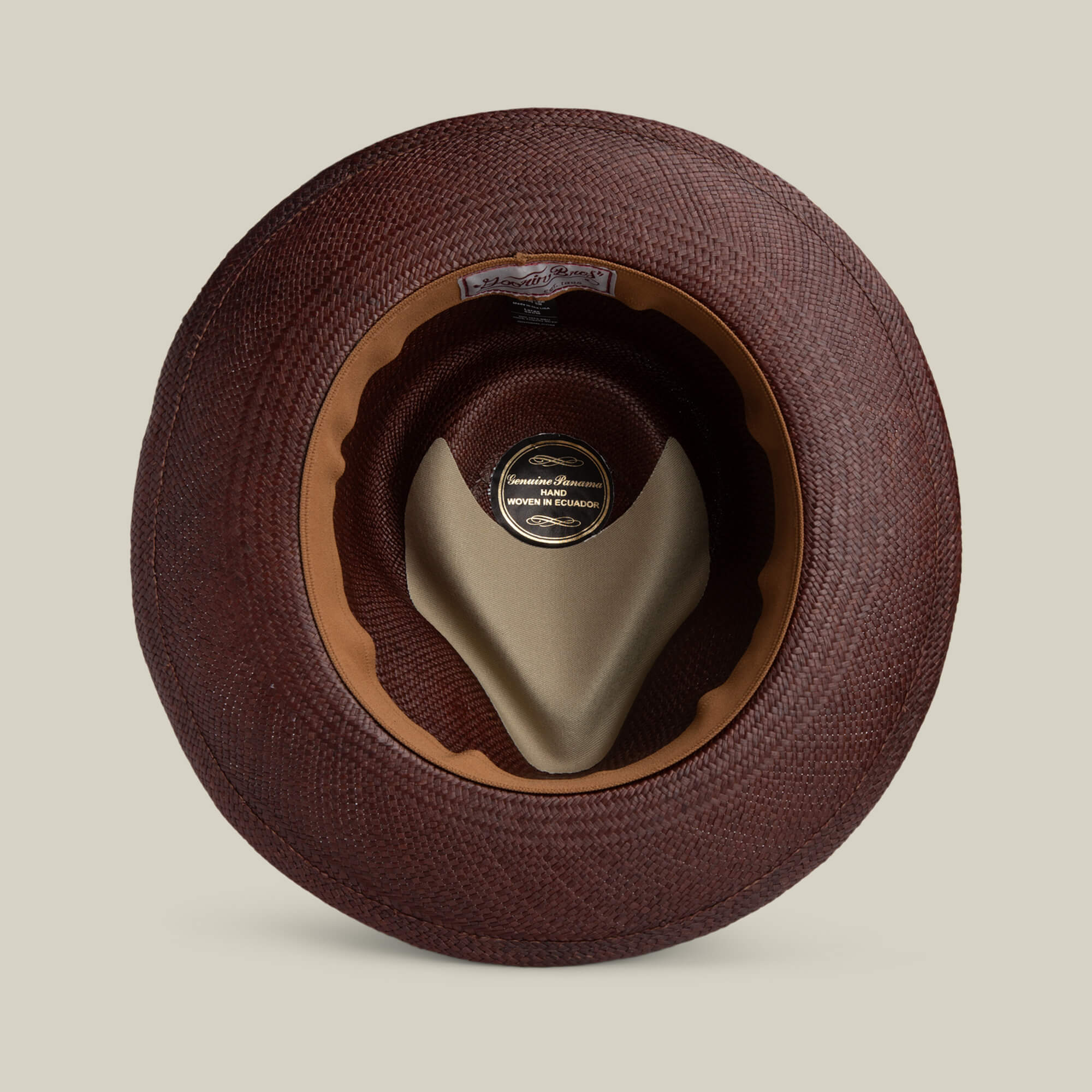 A top-down view of the Goorin Bros. John Sr. toquilla teardrop fedora highlights its brown woven finish, inner leather sweatband, beige crown support, and inside label—offering both style and UPF 50 sun protection.