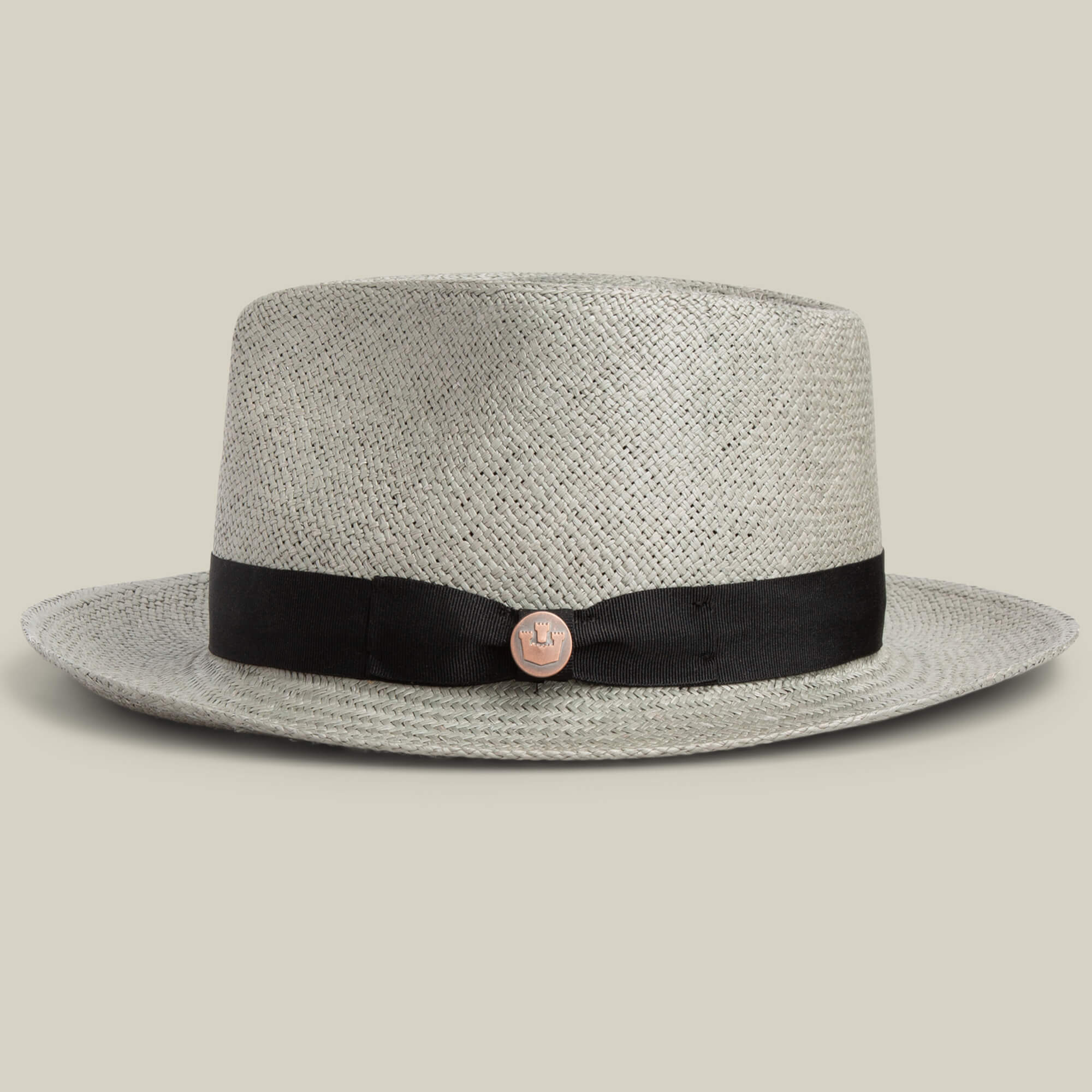 The Goorin Bros. John Sr. is a light gray toquilla straw teardrop fedora with a black ribbon band and round metallic emblem, providing stylish 50 UPF sun protection, shown against a plain background.