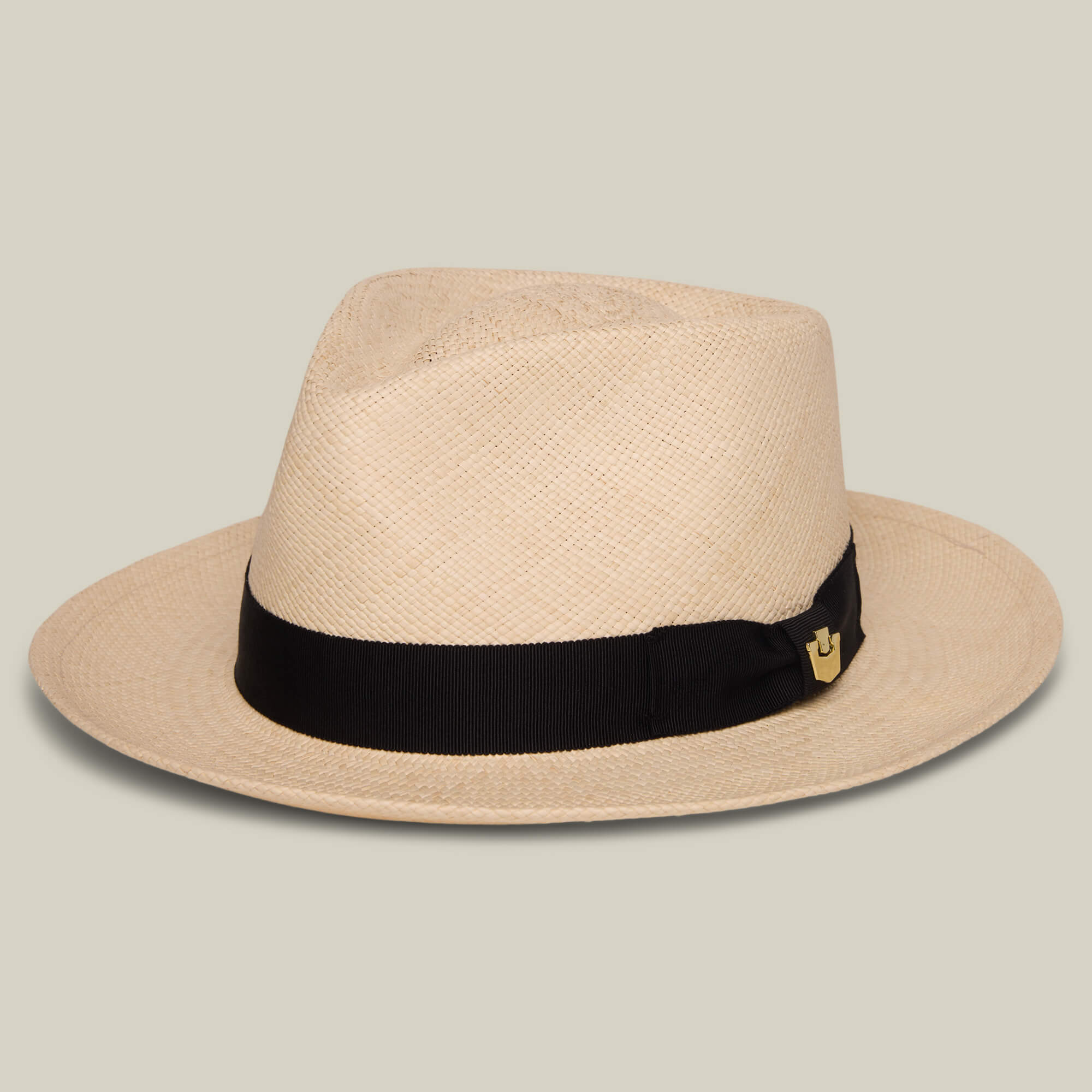 The John Sr. by Goorin Bros. is a beige toquilla teardrop fedora with a black band, small gold emblem, and 50 UPF sun protection, shown on a plain light background.