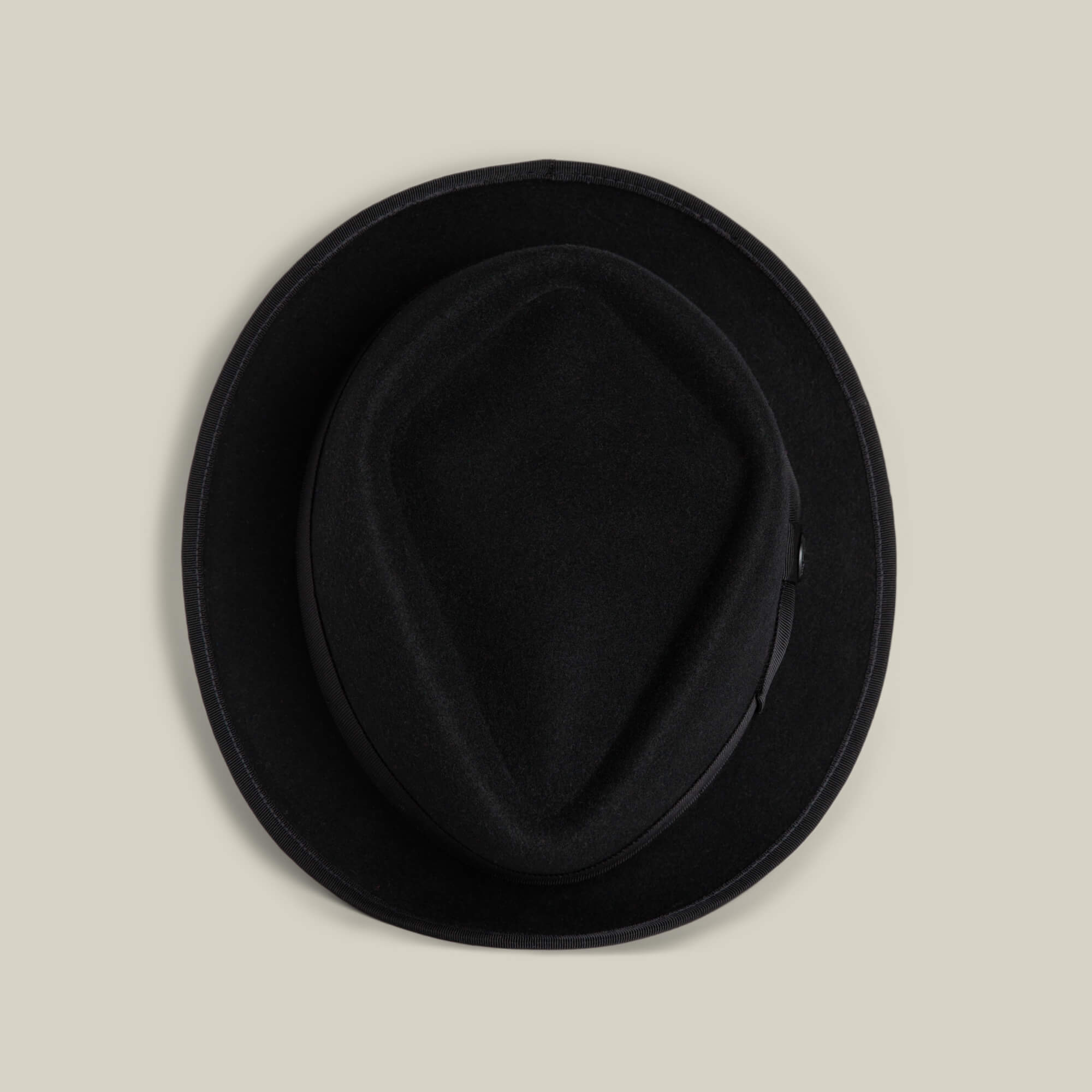 The Goorin Bros. Slick Carter is a black wool short-brim fedora, shown from above on a beige background—an effortless style statement.