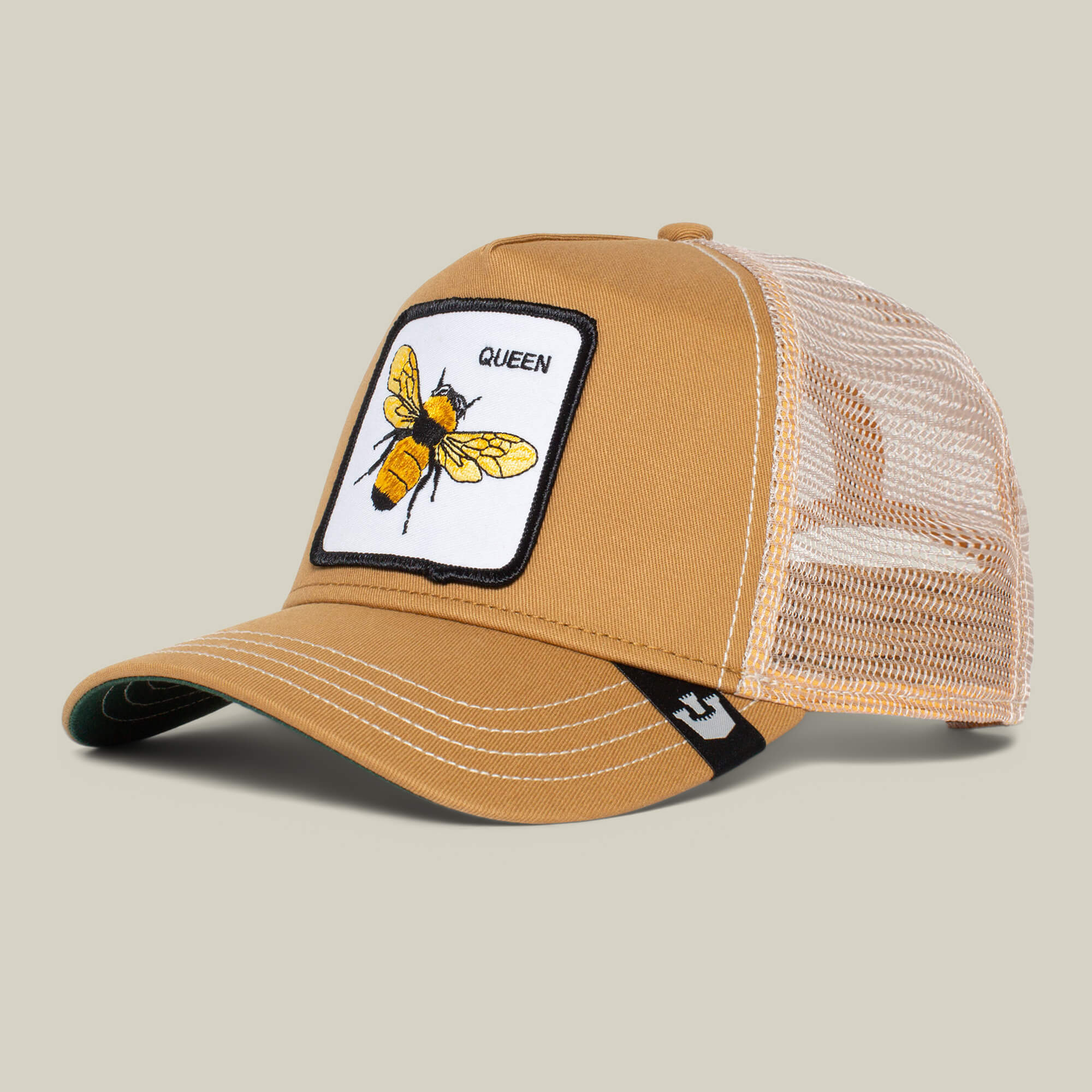 The Farm's "The Queen Bee" mesh trucker hat features a tan design with a front patch of a yellow bee and the word QUEEN—wear it to show off your royal style.