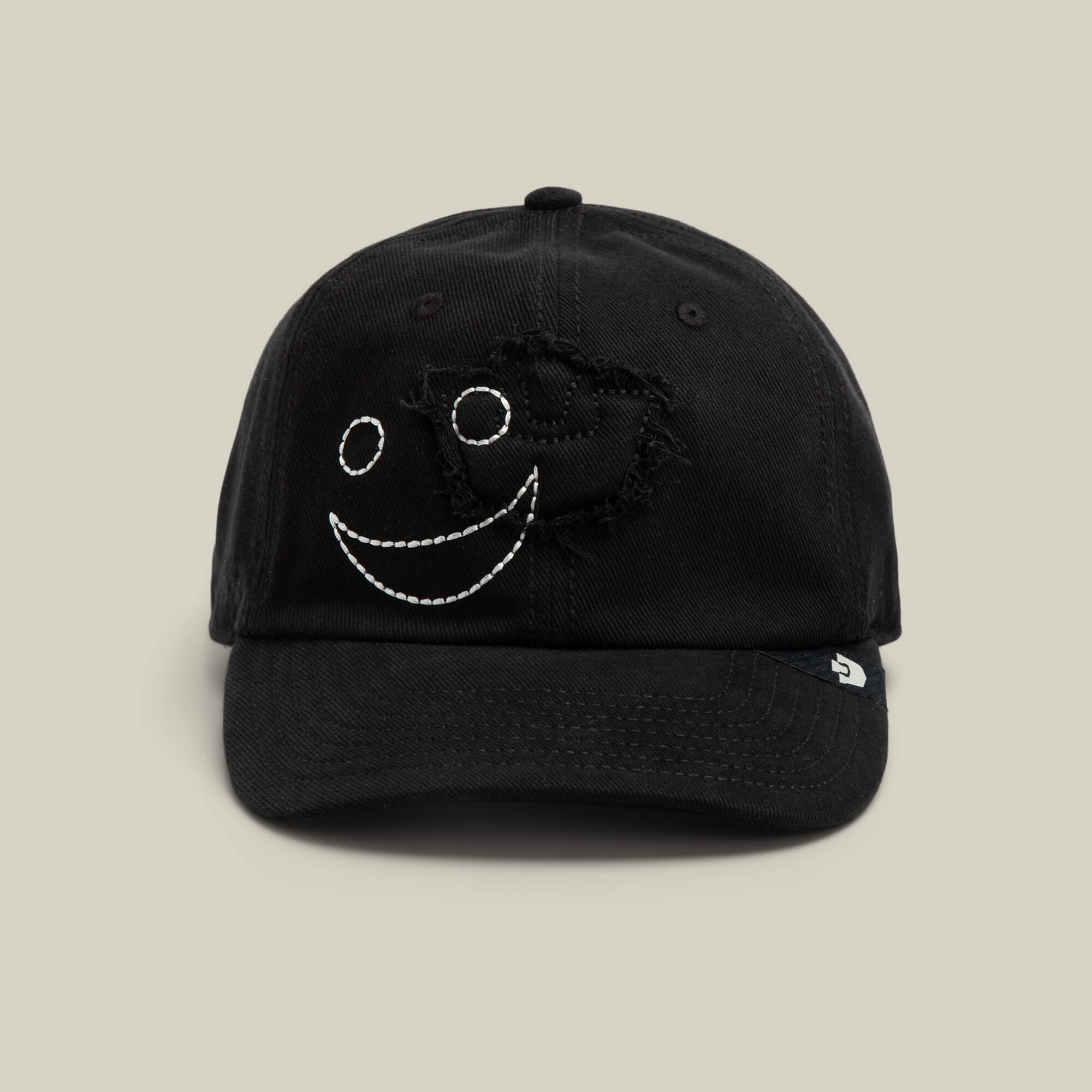 The Fine Headwear cap by Goorin Bros. in VOID color features a stitched white smiley face and distressed detailing, making it a playful addition to any headwear collection.