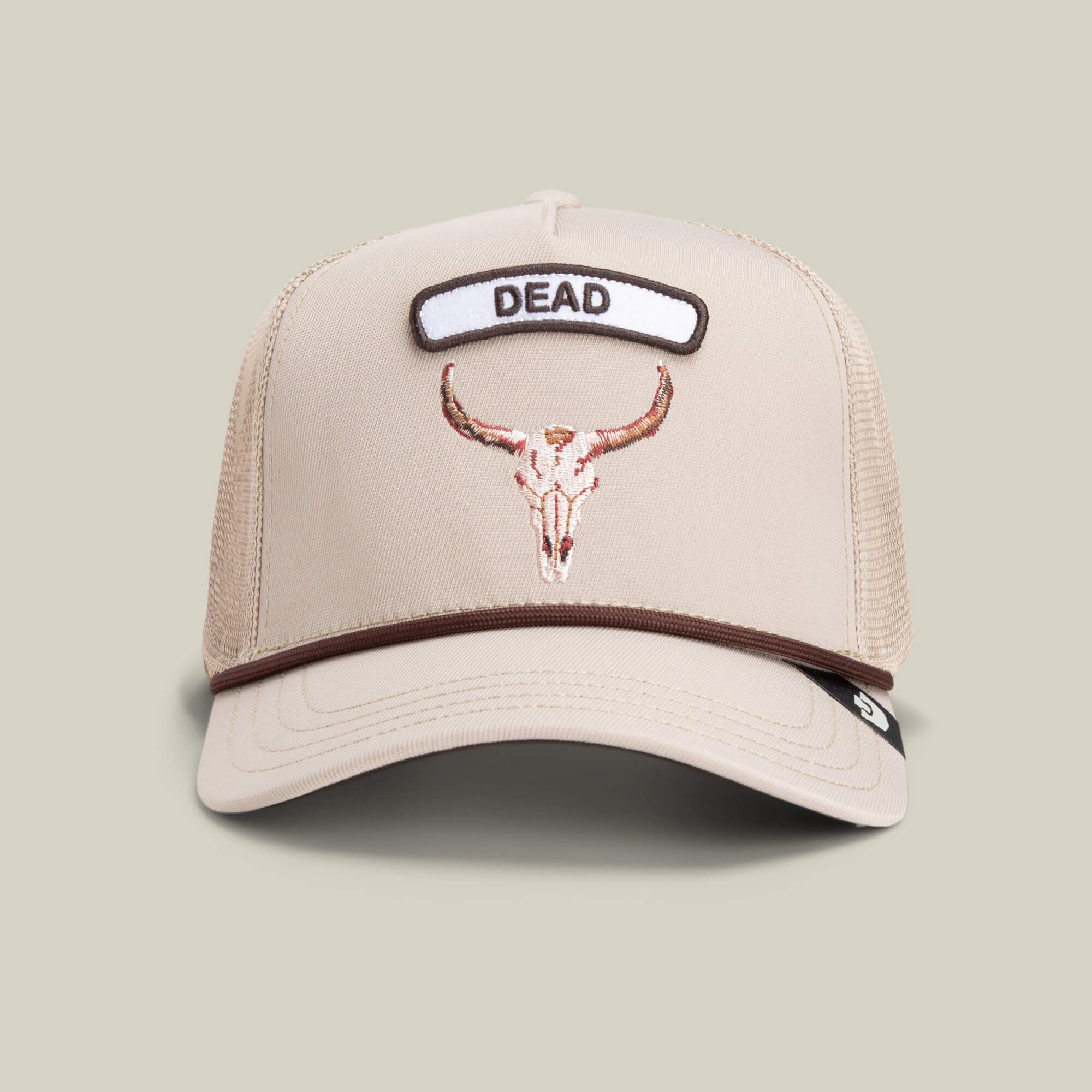 The GB2 Skull by Goorin Bros. is a beige trucker hat with desert tones, mesh back, an embroidered bull skull on the front, and a bold DEAD patch above it.