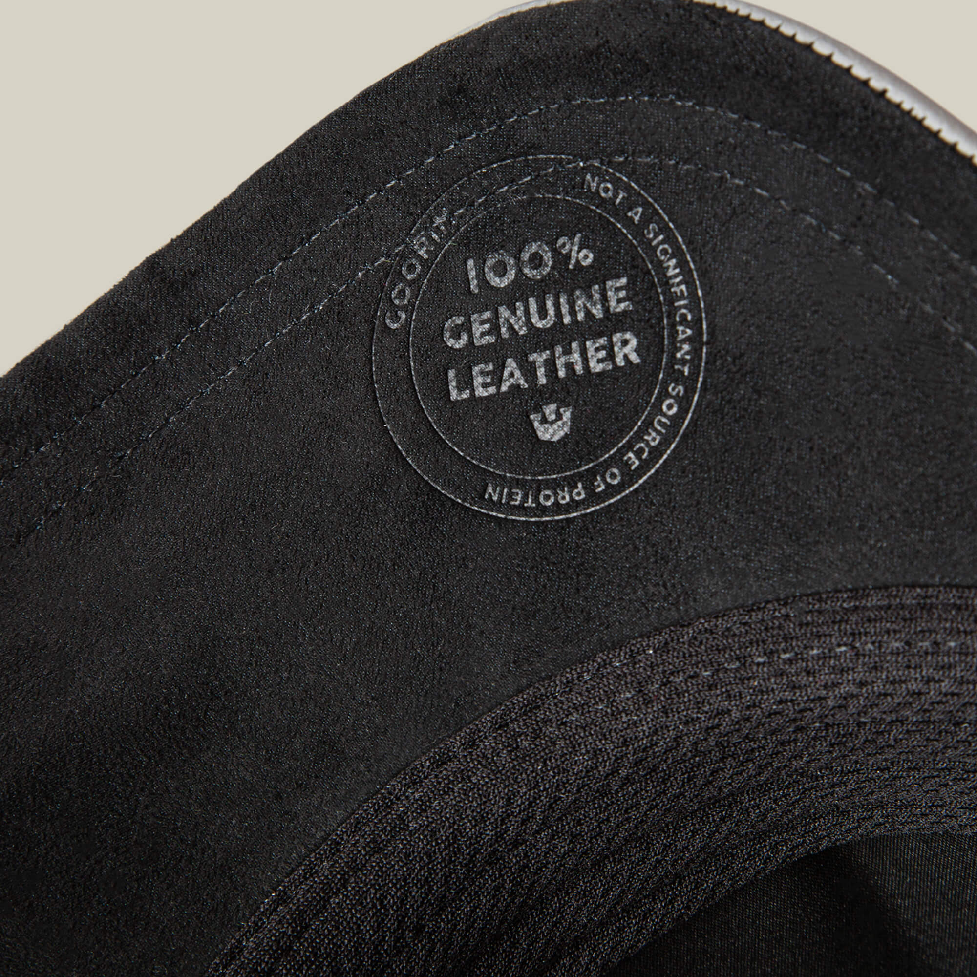 Close-up of the Goorin Bros. LFG Lone Wolf, highlighting its "100% Genuine Leather" label, visible stitching, and textured premium leather material.