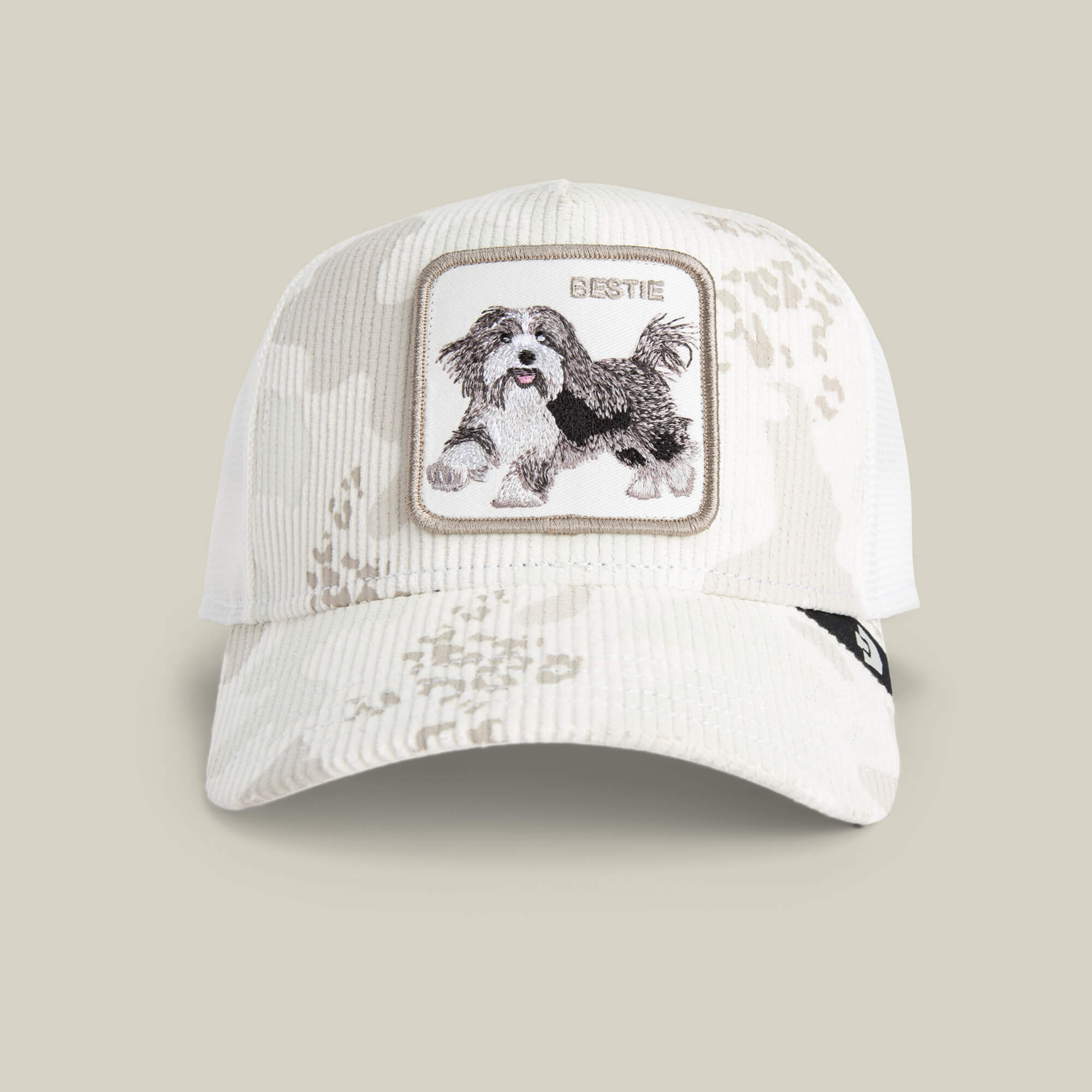 The Goorin Bros. Bestie Camo is an off-white snow camo corduroy baseball cap with a front patch that has an embroidered black and white dog and the word "BESTIE.
