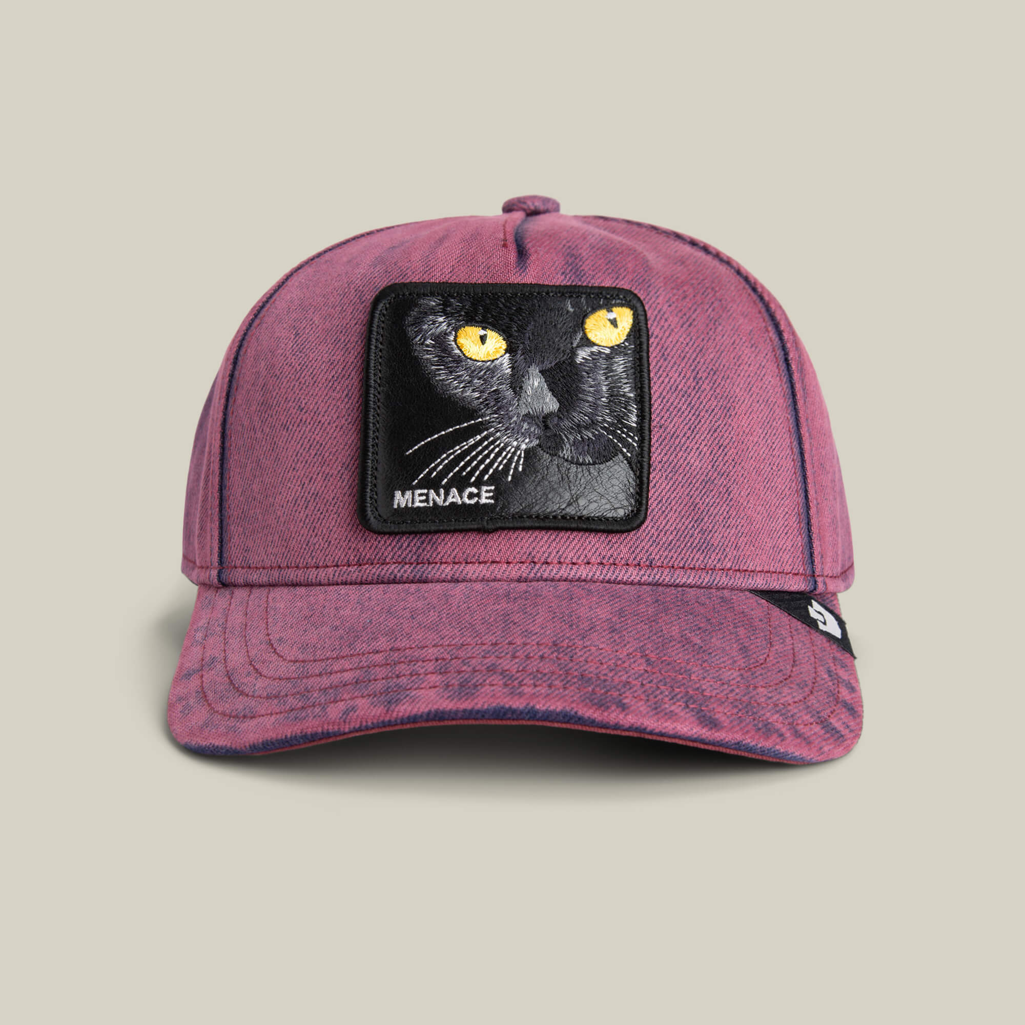 The Rail Bird cap by Goorin Bros. is an overdyed purple denim hat featuring a patch with an embroidered black cat face and "MENACE" below—ideal for expressing your mischievous side.