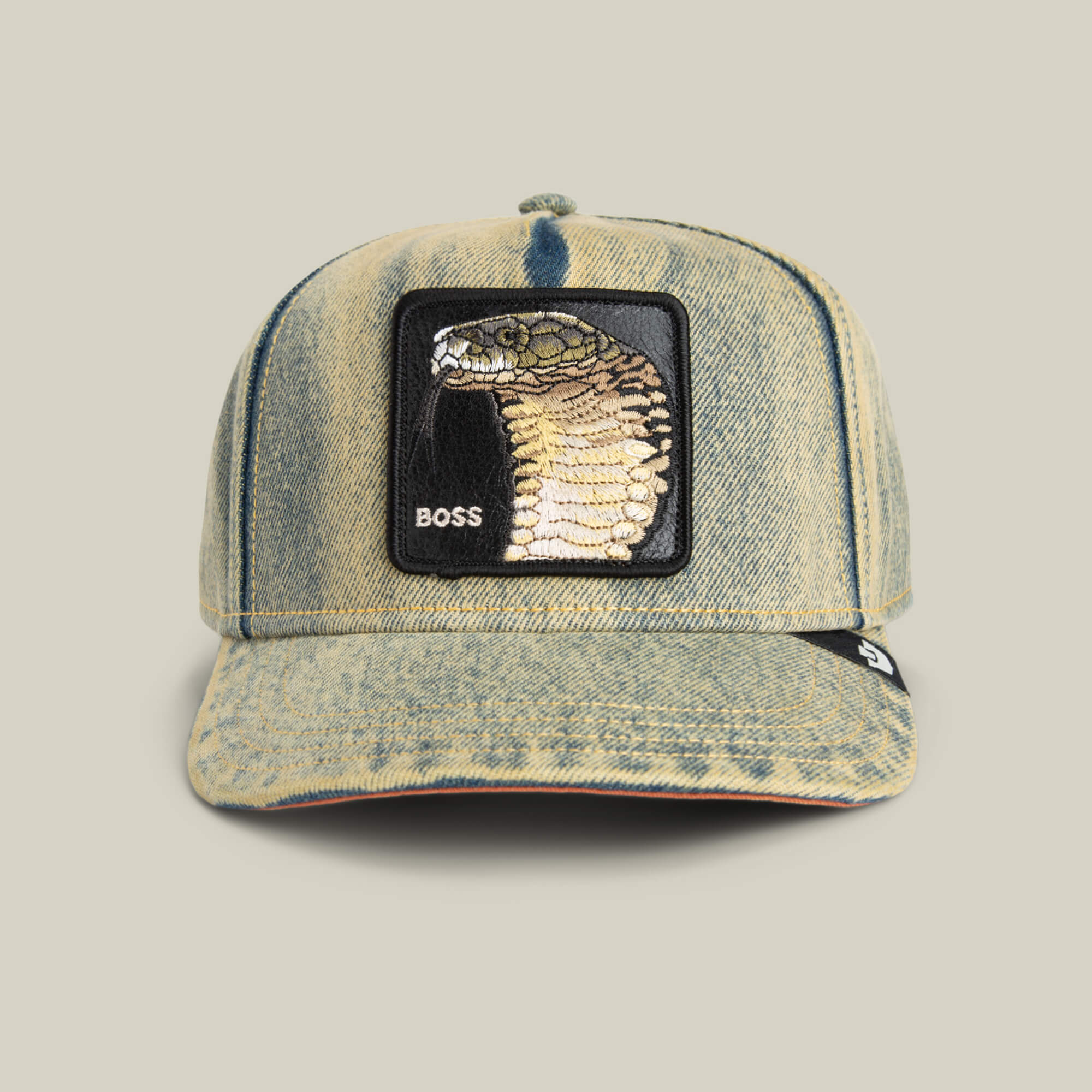 The Goorin Bros. Pit Boss is a denim hat with a striking cobra patch and "BOSS" embroidery on the front, delivering an edgy statement to any outfit.