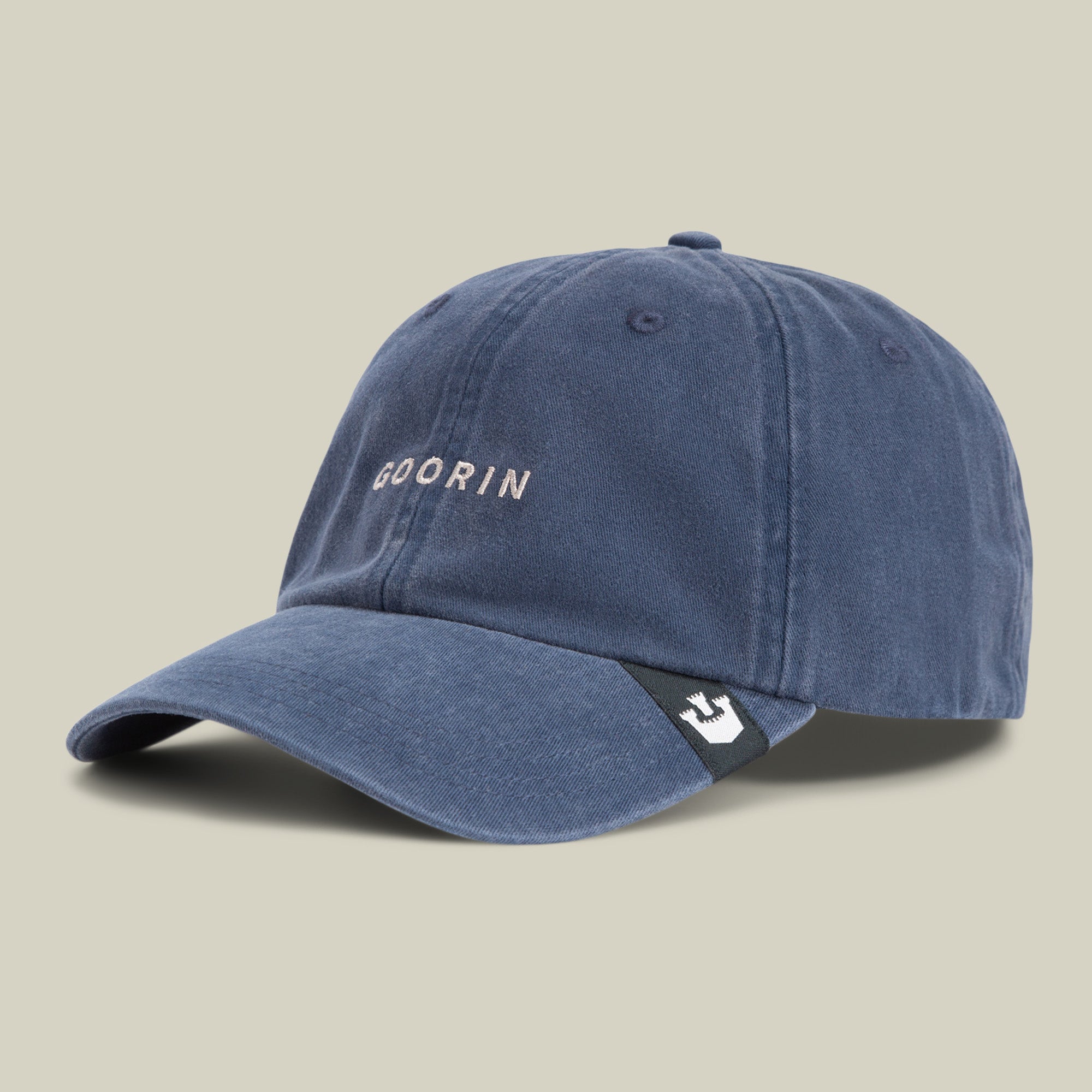 The Papa Cap Italiano by Goorin Bros. is a blue vintage cap featuring "GOORIN" embroidered in white on the front and a small black tag with a white emblem on the left side of its curved brim, set against a plain background.