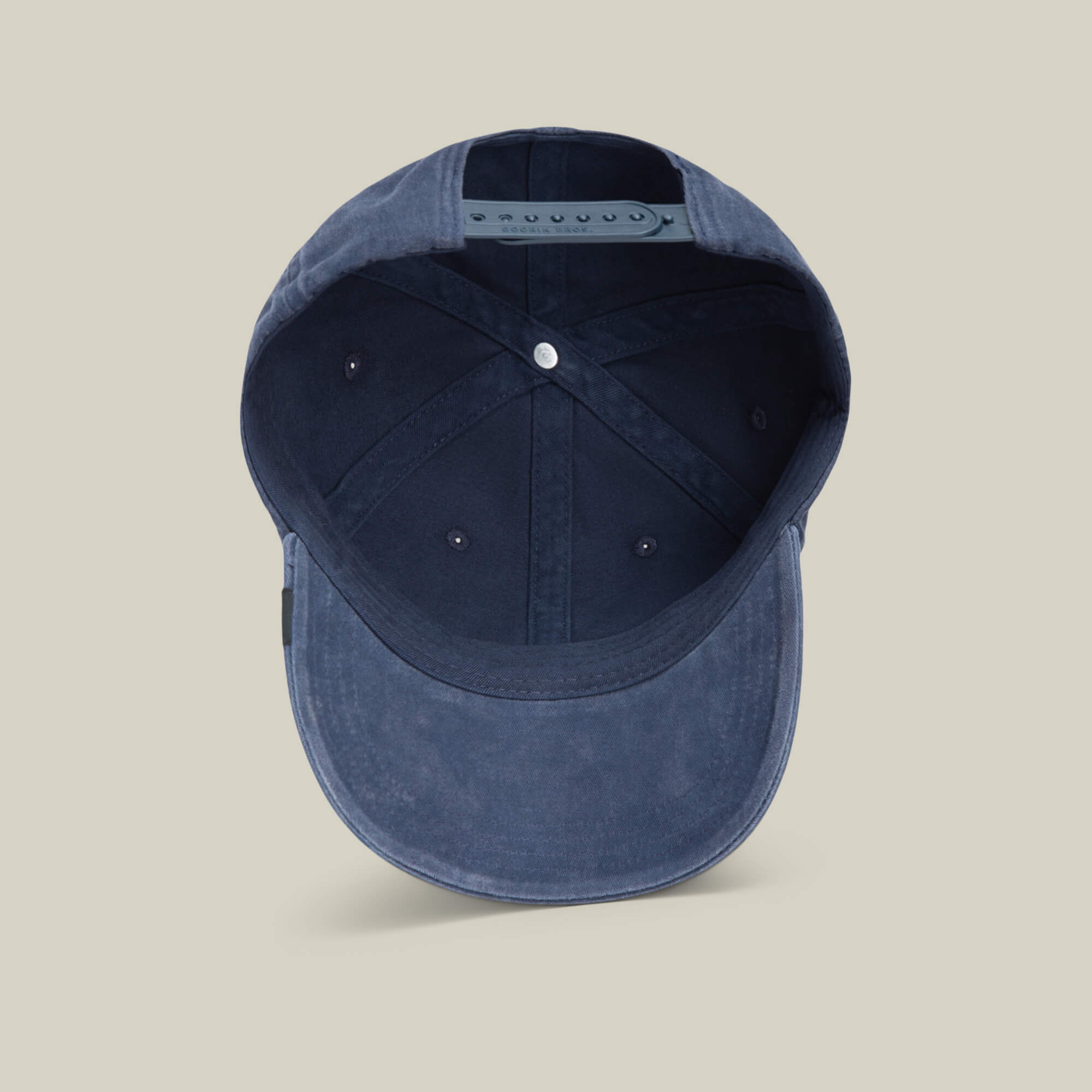 The Goorin Bros. Papa Cap Italiano in navy blue is shown from below, featuring its adjustable strap and interior stitching, all set against a plain background.
