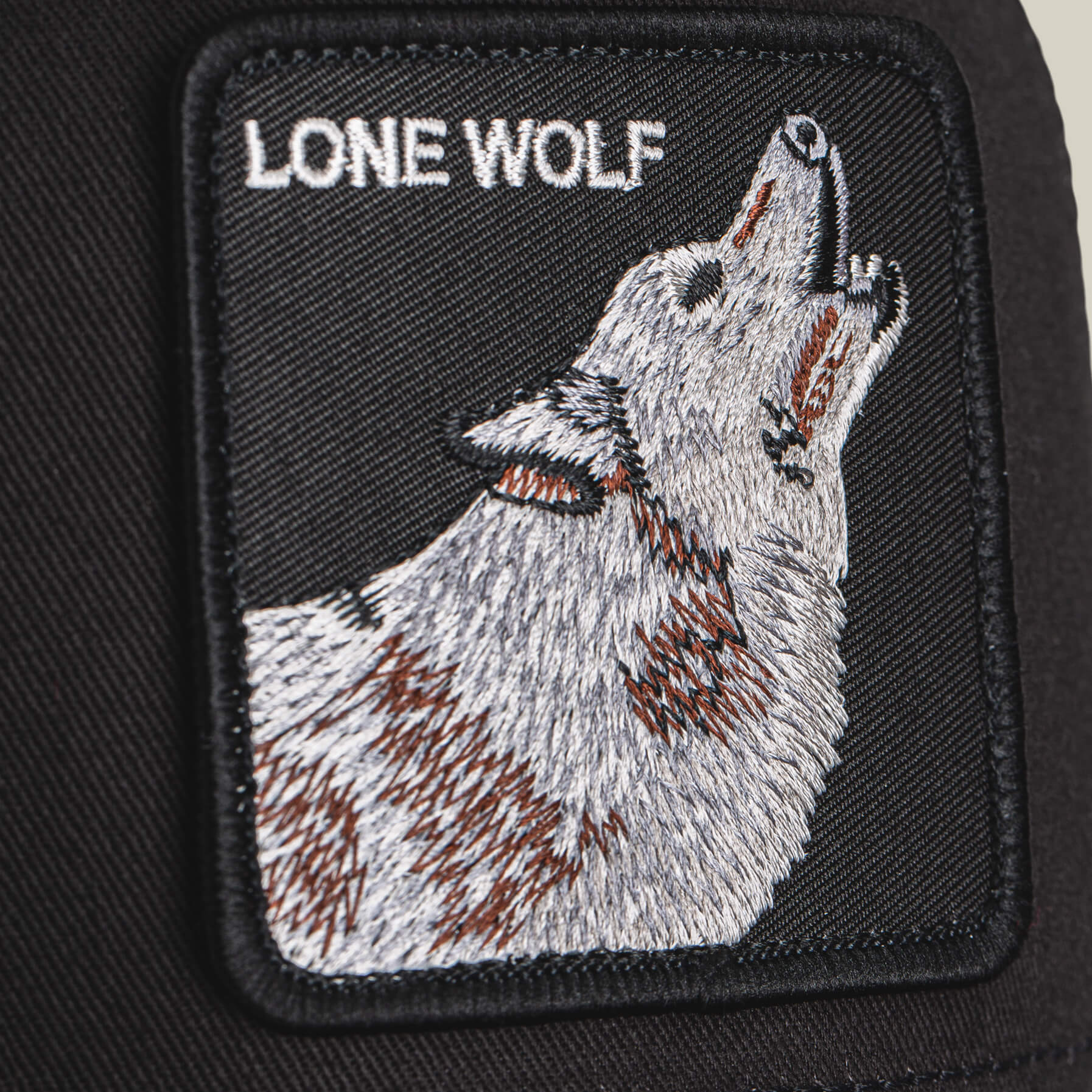 The Lone Wolf patch by Goorin Bros. features a howling wolf and "LONE WOLF" text on black fabric—an embroidered rectangle ideal for bringing bold, outlaw style to any trucker’s gear.