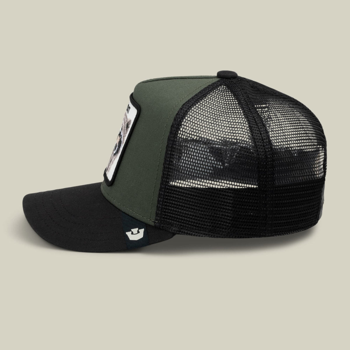 The Goorin Bros. Bandit Trucker is a color-blocked snapback hat with an olive green front panel, black bill, and black mesh back, featuring a small embroidered patch on the side, shown against a neutral studio background.