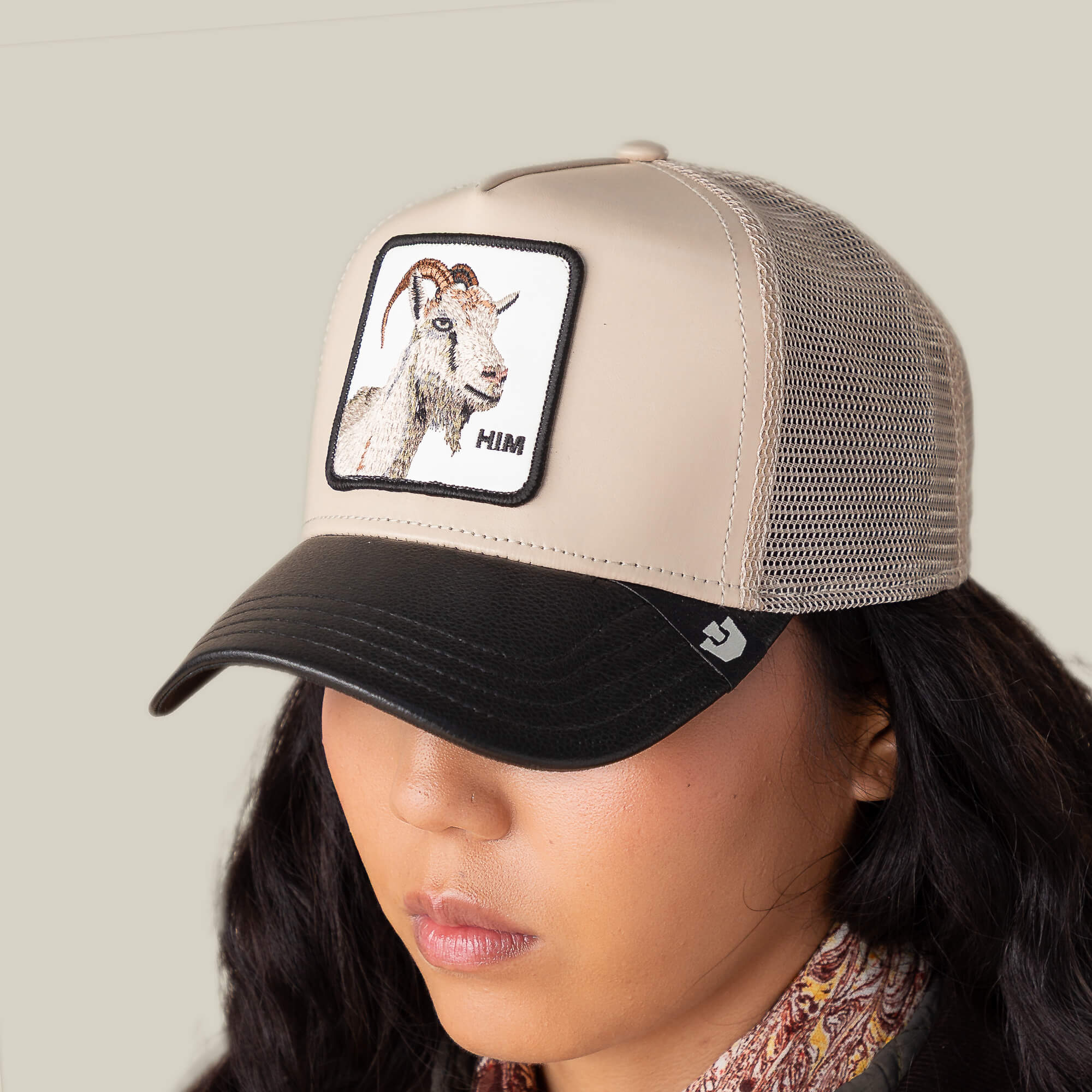 A woman wearing the Goorin Courtside Him faux leather hat featuring a subtle GOAT patch.