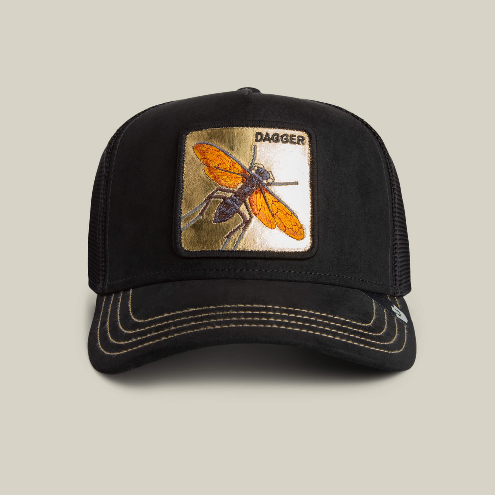 The Golden Dagger by Goorin Bros. is a black trucker hat with yellow stitching and a front patch featuring an orange insect and "Golden Dagger" text, making it perfect for bold, standout style.