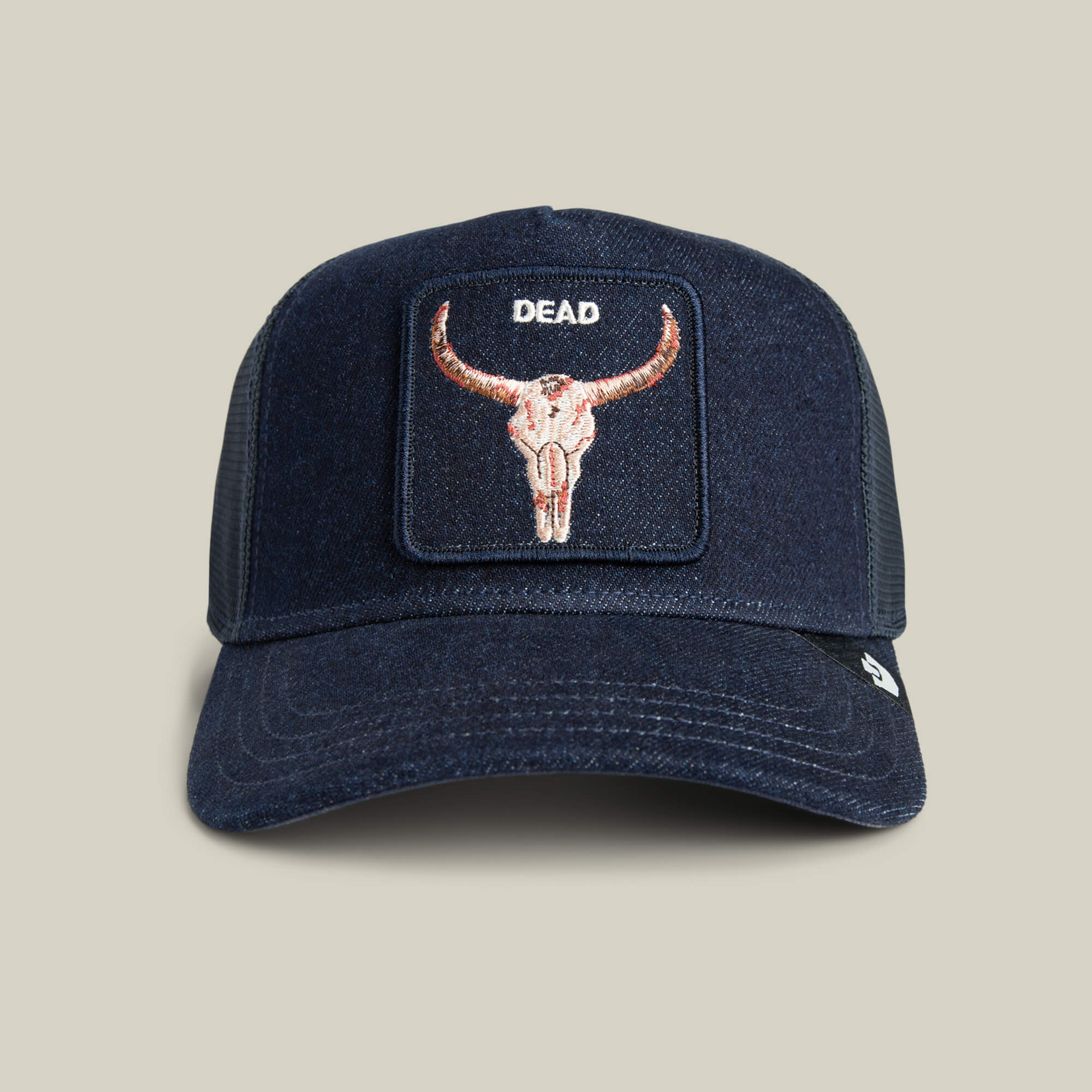 The Goorin Bros. Denim Dead is a navy blue biker cap with bold bull skull embroidery and the word "DEAD" above, shown on a light neutral background.