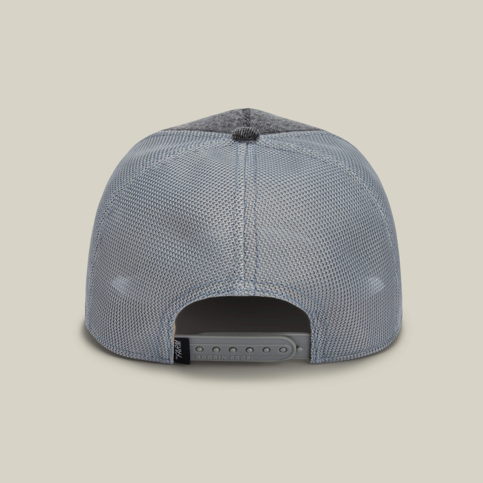 The back view of The Mamba by Goorin Bros. showcases a gray mesh snapback with an adjustable plastic strap and a black tag on the left side.