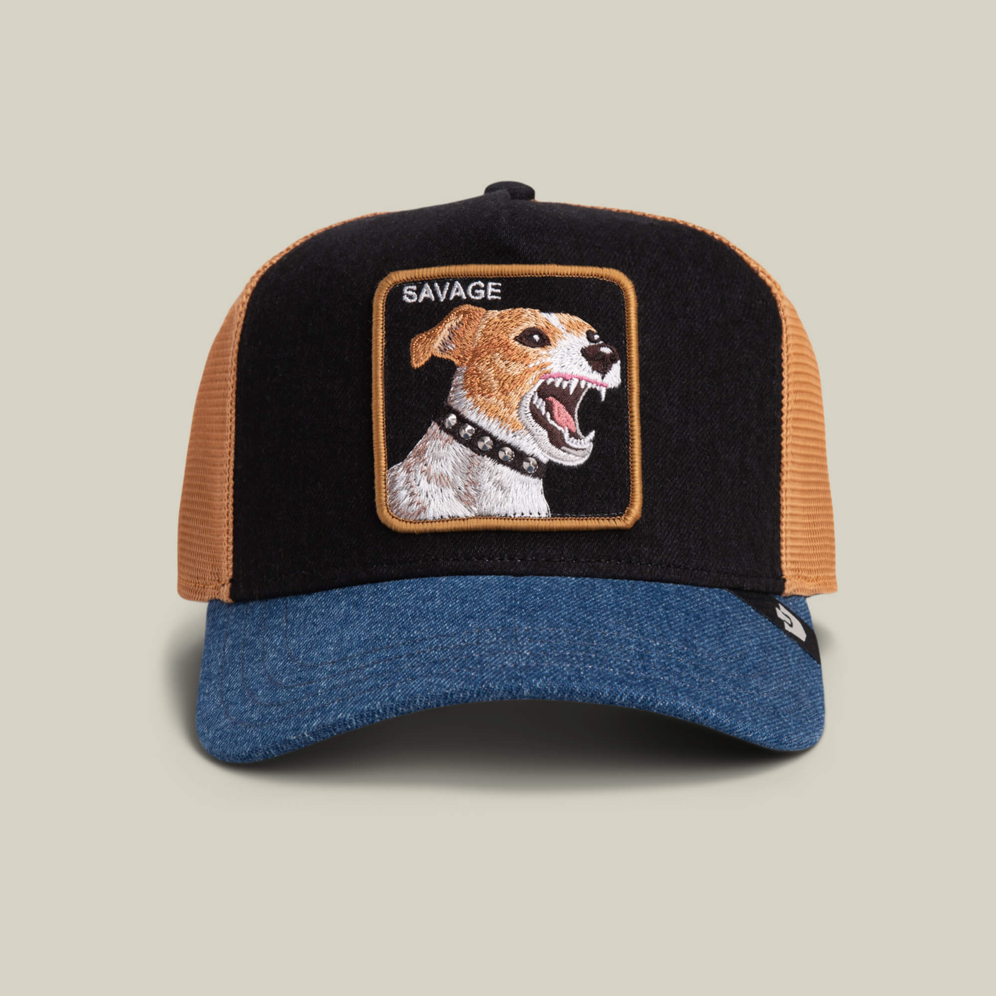 The Goorin Bros. Savage Dawg is a BLACK DENIM trucker hat with a blue brim, featuring a patch of an embroidered snarling dog in a spiked collar and the word "SAVAGE" above the image.