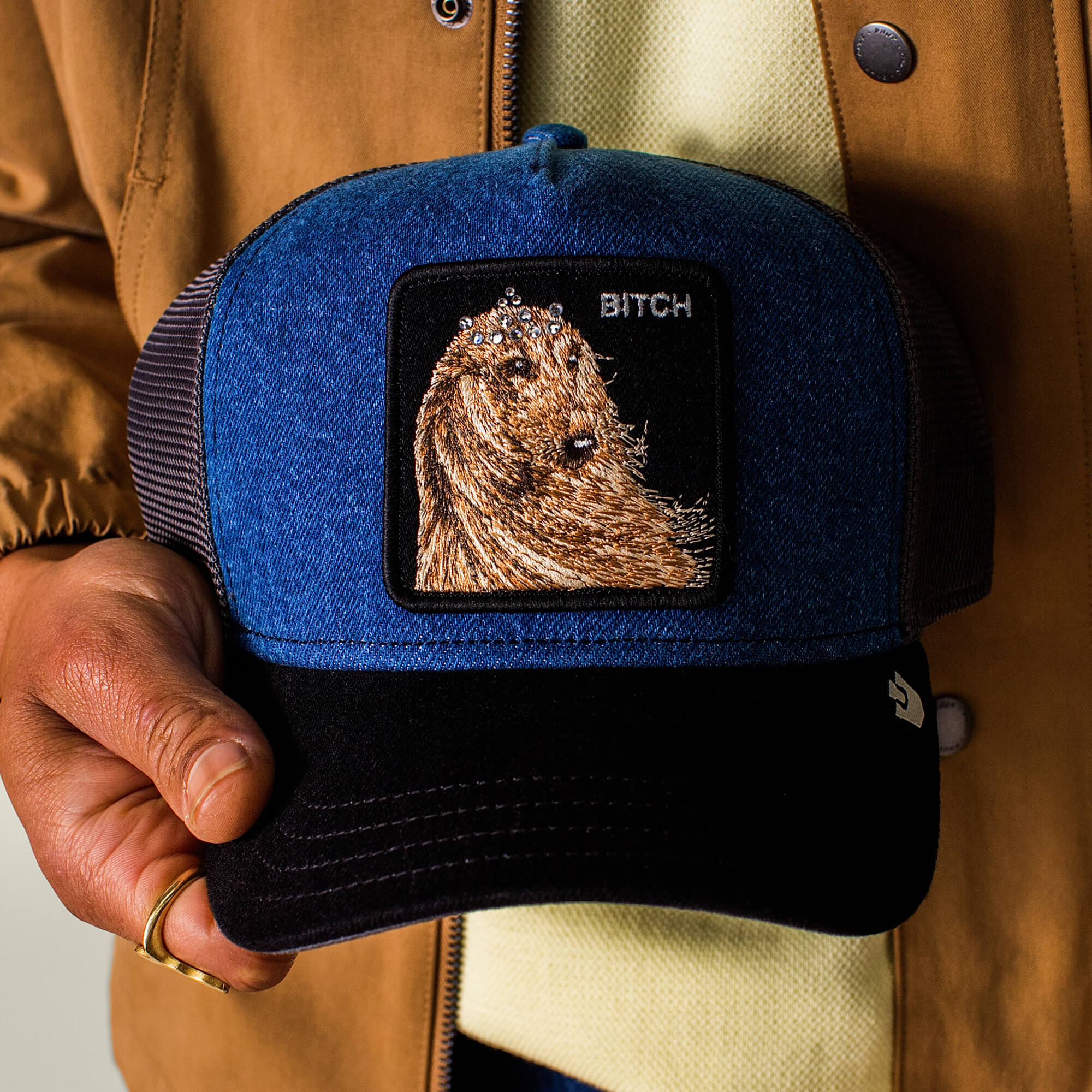 Person wearing the Goorin Bros. Hound Dawg hat, featuring a blue and black denim crown and an embroidered hound dog patch on the front.