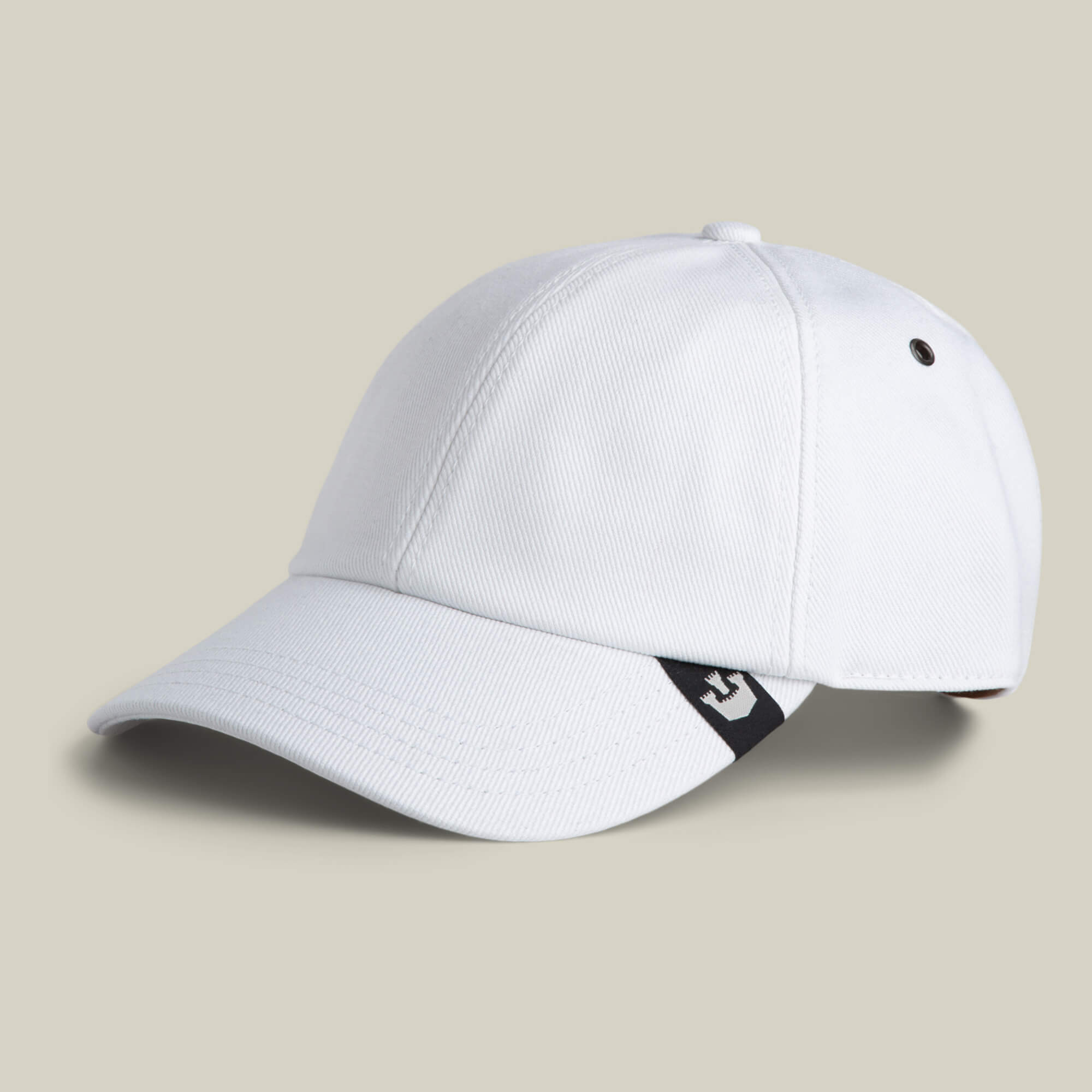 The Clean Denim Papa by Goorin Bros. is a plain white dad cap featuring a curved brim and a small black and white tag on the side, presented against a neutral background.