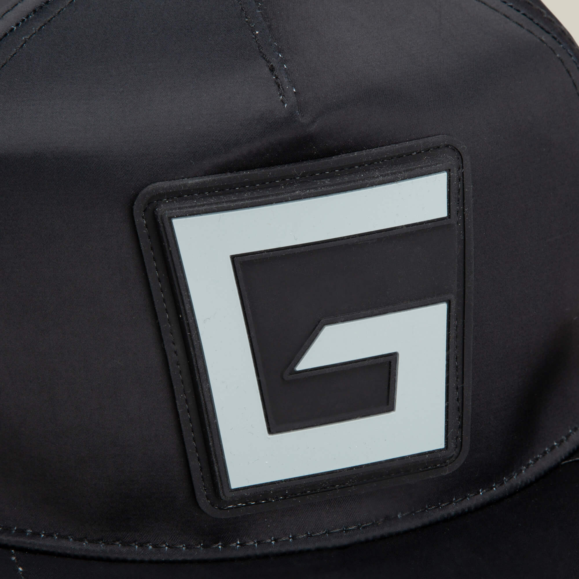 Close-up of the Pole Position - Road Kill racing cap by Goorin Bros., featuring a large, stylized letter G patch on the black front panel.