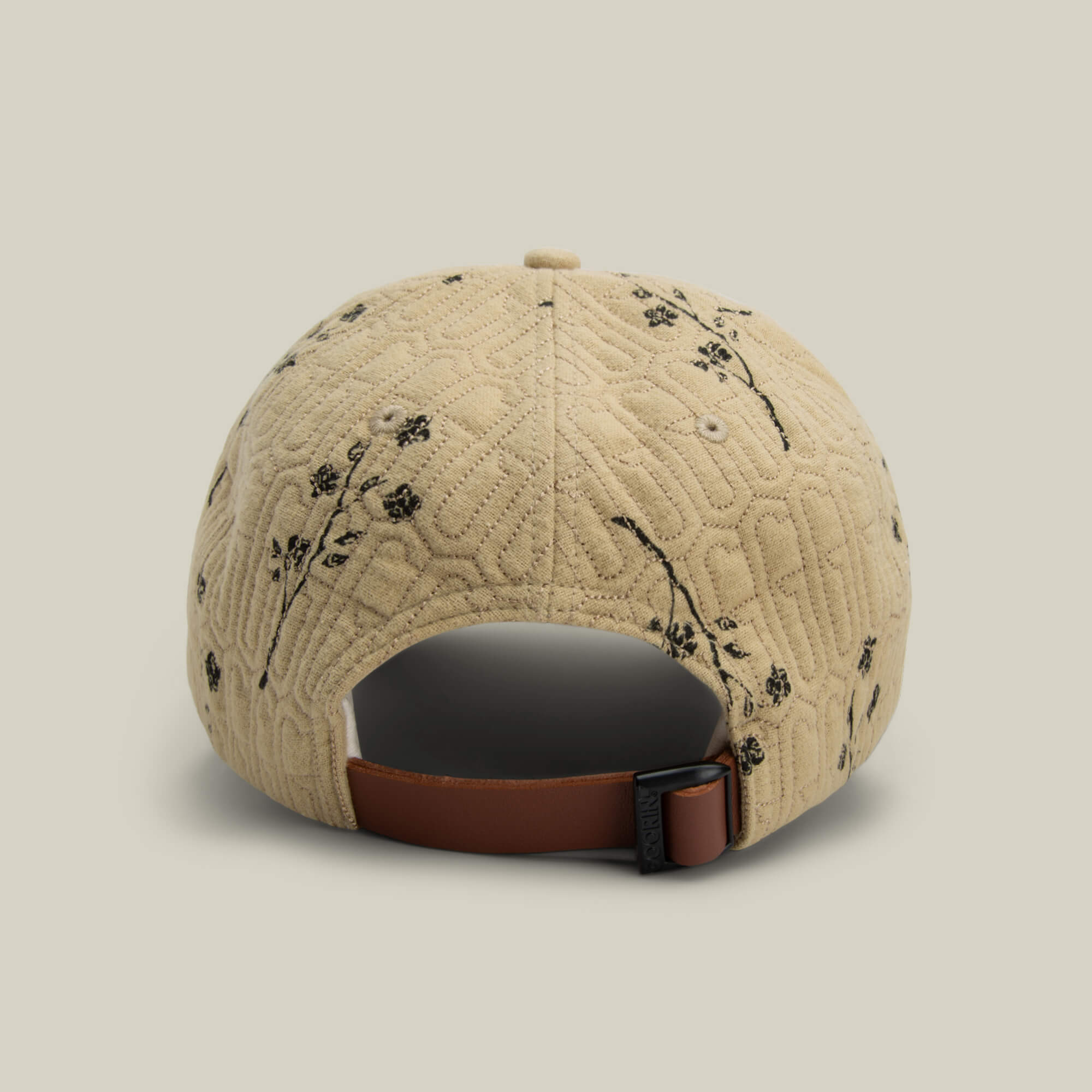The Vol. 1 - Quiltbag: G Papa cap by Goorin Bros. features beige quilted floral fabric, black embroidery, and a brown adjustable strap with metal buckle—blending comfort and unique style for everyday wear.