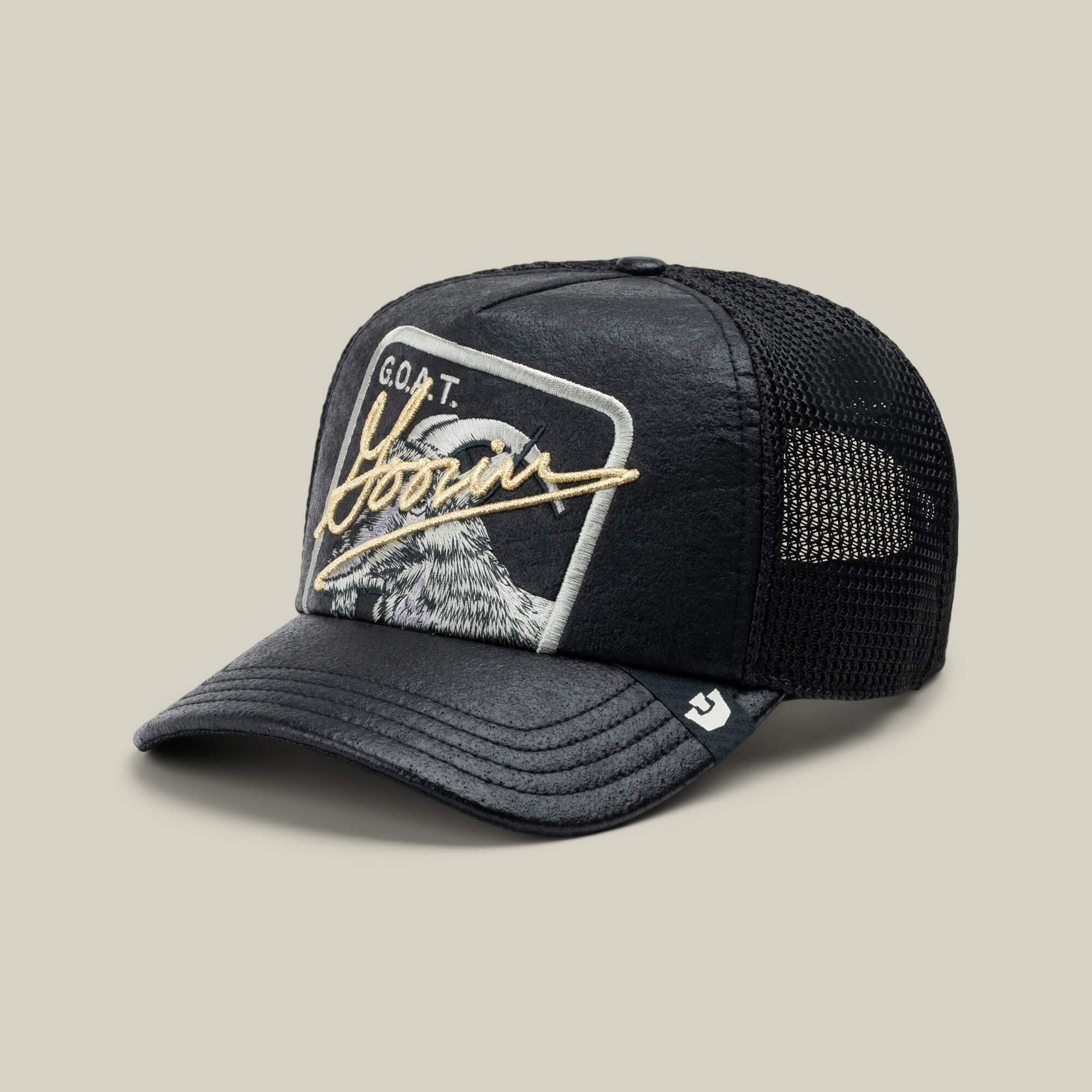 The Goorin Bros. NeoBrand GOAT is a black mesh trucker hat with a curved brim and an eagle patch reading "G.O.A.T. Born"—ideal for pairing with monochrome sneakers for a bold, laid-back style.