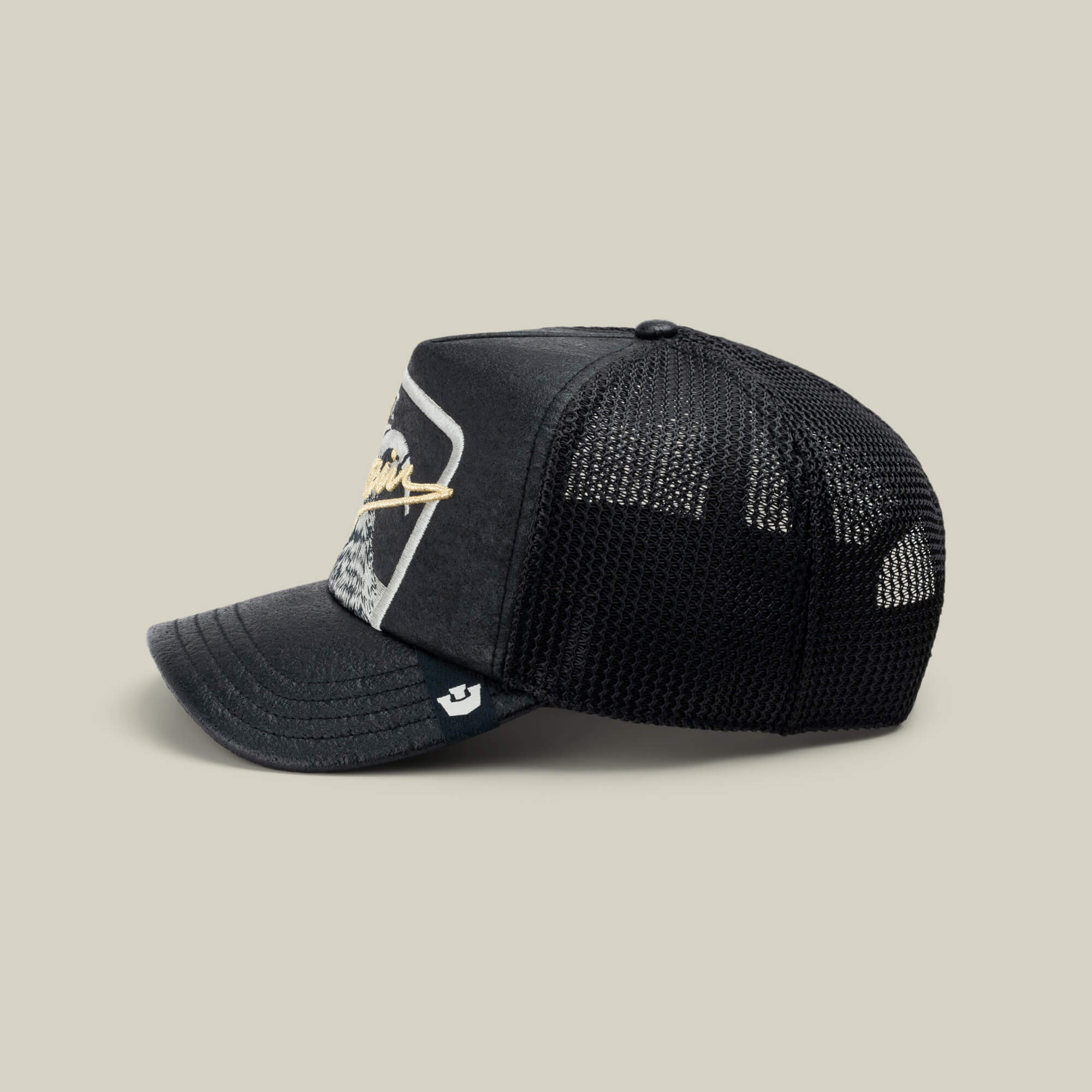 The NeoBrand GOAT by Goorin Bros. is a black mesh trucker hat with a curved bill, front patch, and side white logo tag—ideal to pair with your favorite monochrome kicks or GOAT gold script sneakers.