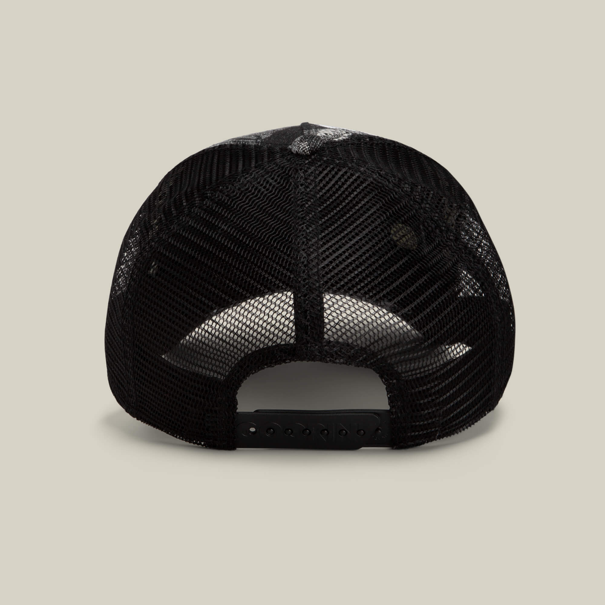 The Bone Head Unalive trucker hat by Goorin Bros. is displayed from the back, showcasing its black breathable mesh back and adjustable snapback closure against a plain light beige background.