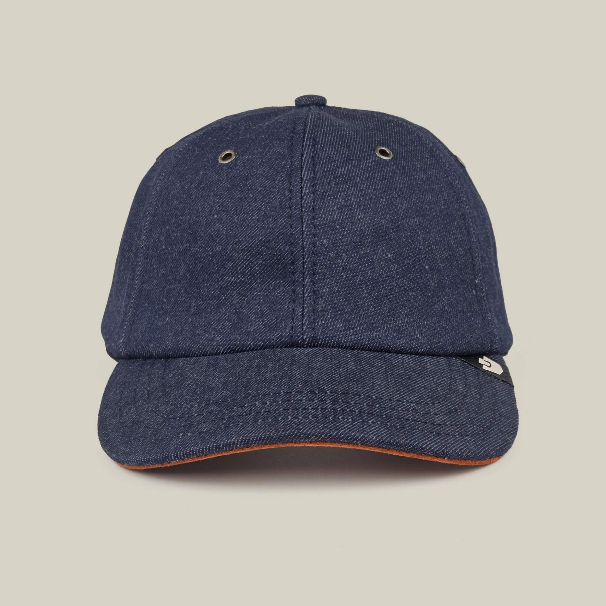 The Legend Ridge by Goorin Bros. is a dark denim baseball cap, made in the USA, with metal eyelets and a small black and white side tag, shown on a plain beige background.