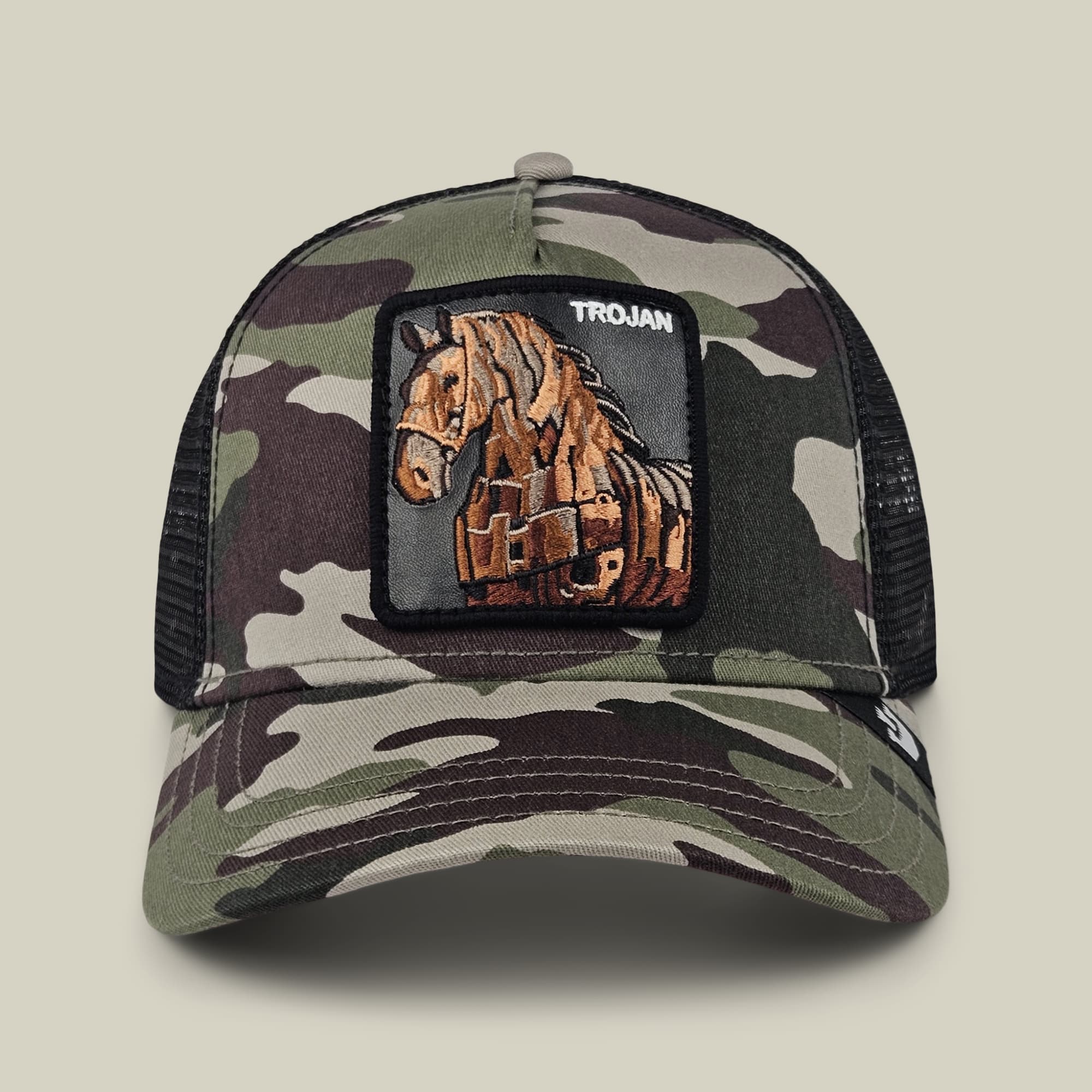 The Goorin Bros. 99 Strong trucker hat features a camouflage pattern in green and brown tones with a mesh back panel and an embroidered horse patch on the front.