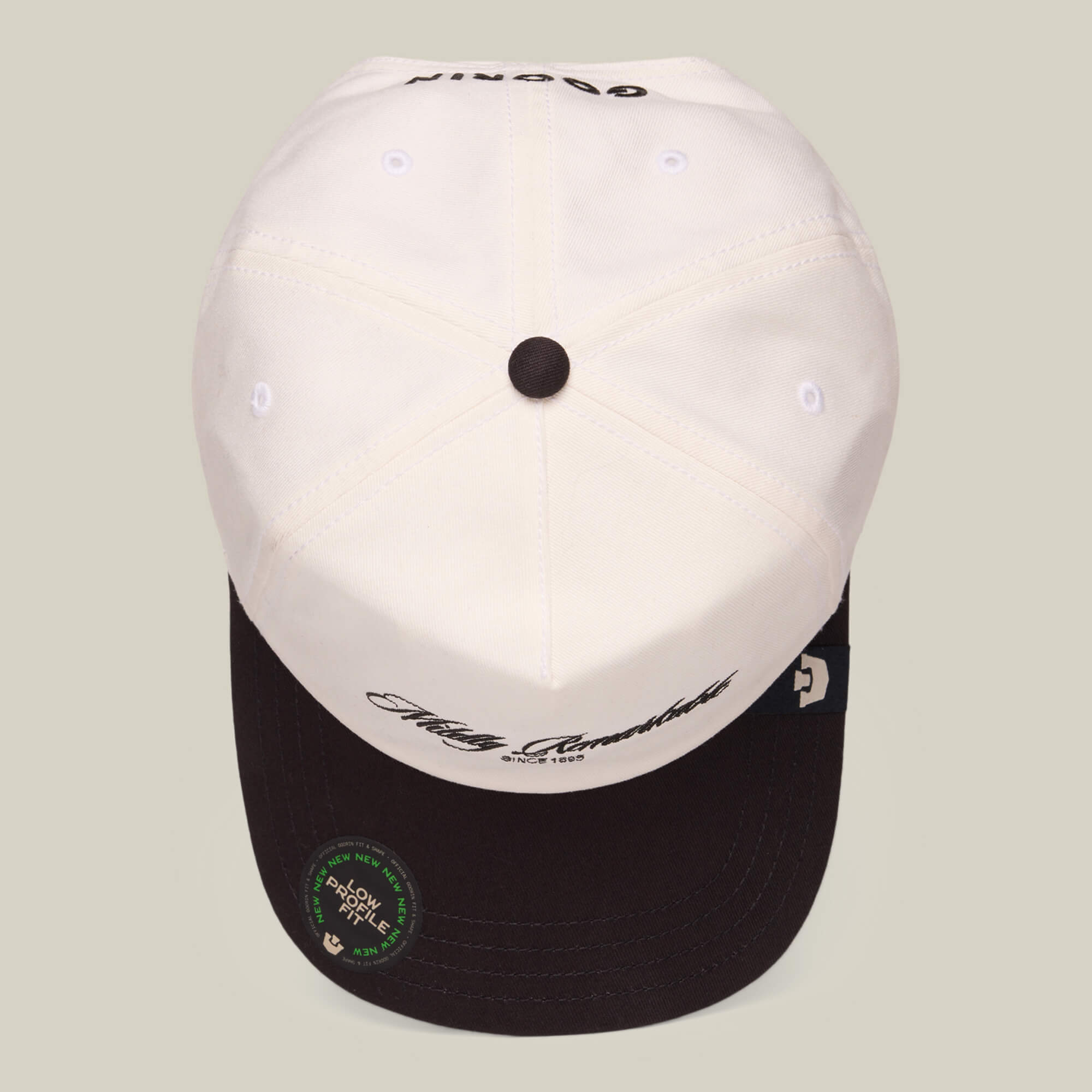 The Goorin Bros. Mildly Remarkable Script hat features a white crown, black brim, classic script embroidery on the front, and a round authenticity sticker on its low pro fit brim.