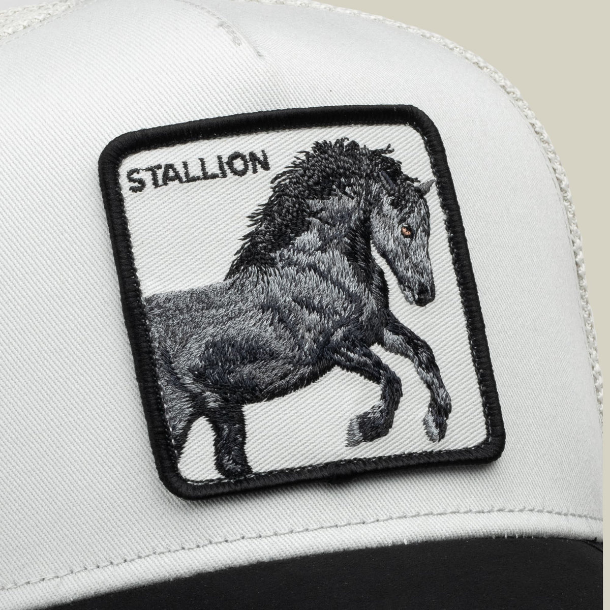 The Goorin Bros. Digital Stallion trucker hat features a white front and black back with an embroidered black stallion patch and text logo on the crown, shown in a close-up product shot.