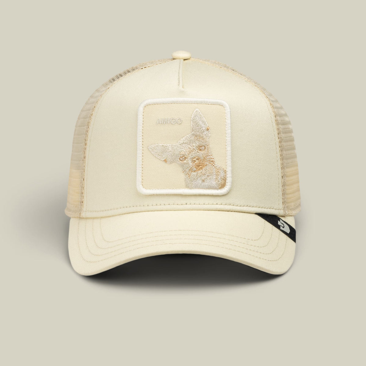 The Goorin Bros. Tonal Amigo trucker hat in cream features a mesh back, embroidered patch on the front, and snapback closure, shown on a neutral background.