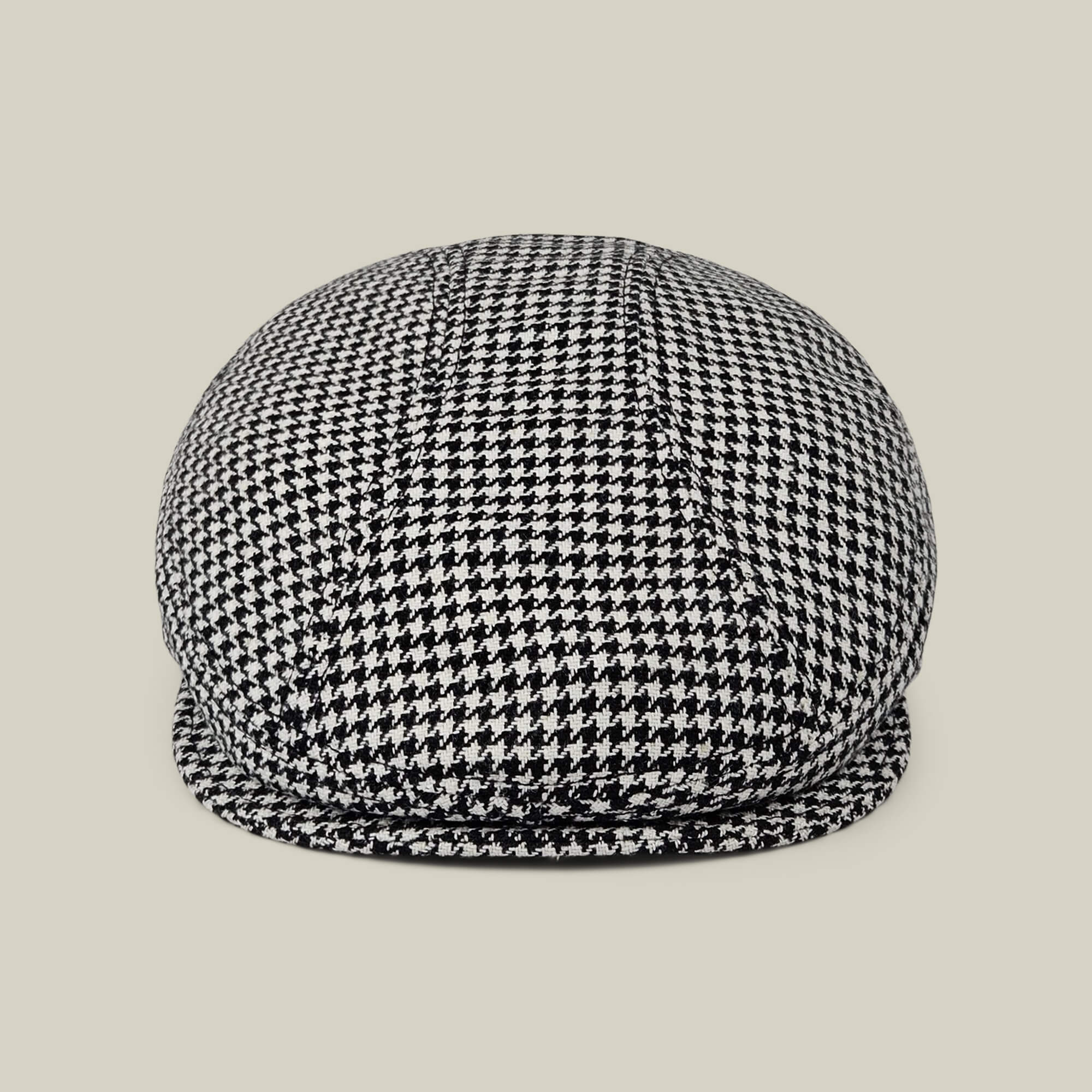 The Norwood flatcap by Goorin Bros., in Void Black and Dust White houndstooth, made in the USA, is shown front-facing against a plain beige background.