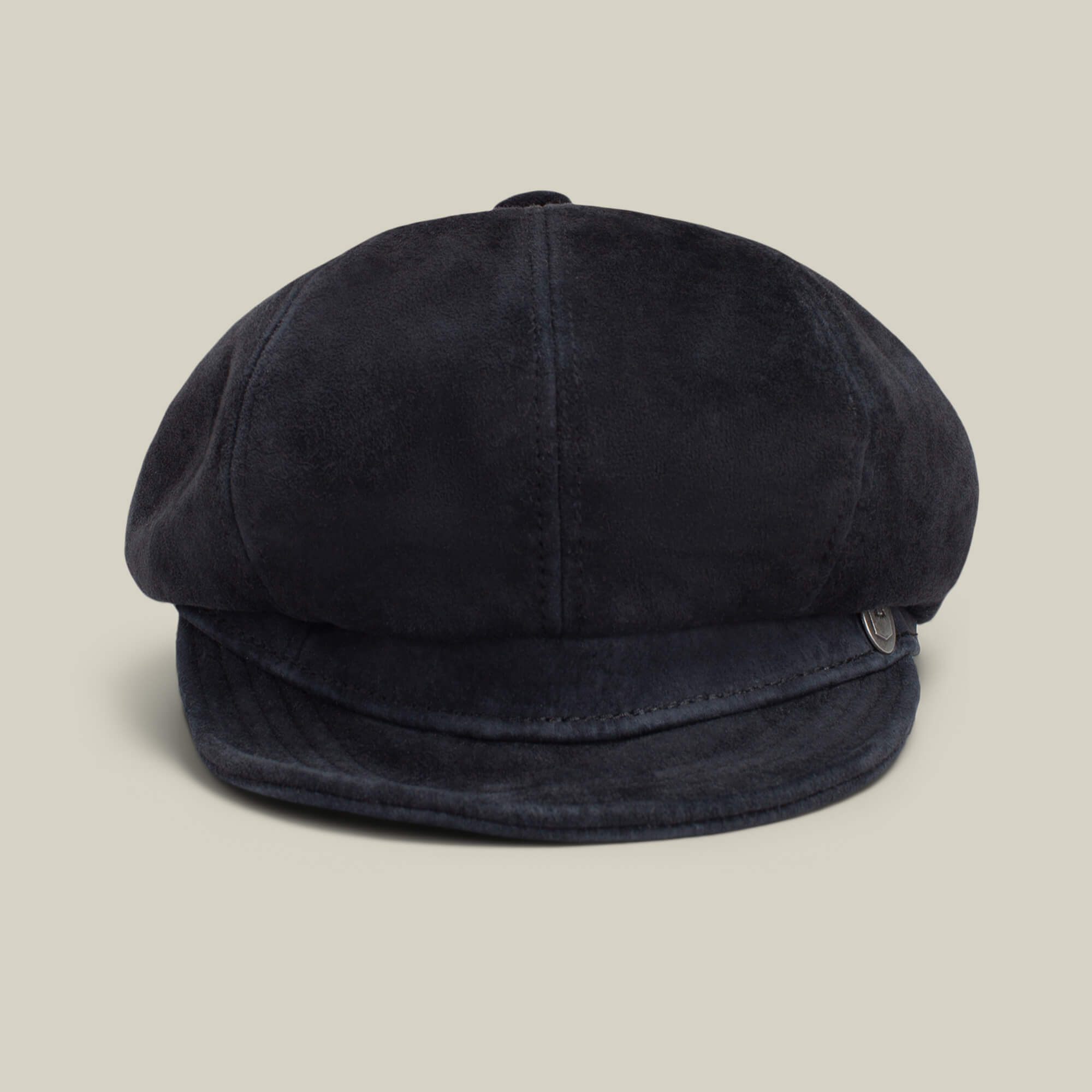 The Ruthy by Goorin Bros. is a black suede cabbie-style flatcap with a short, curved brim, shown against a plain beige background.