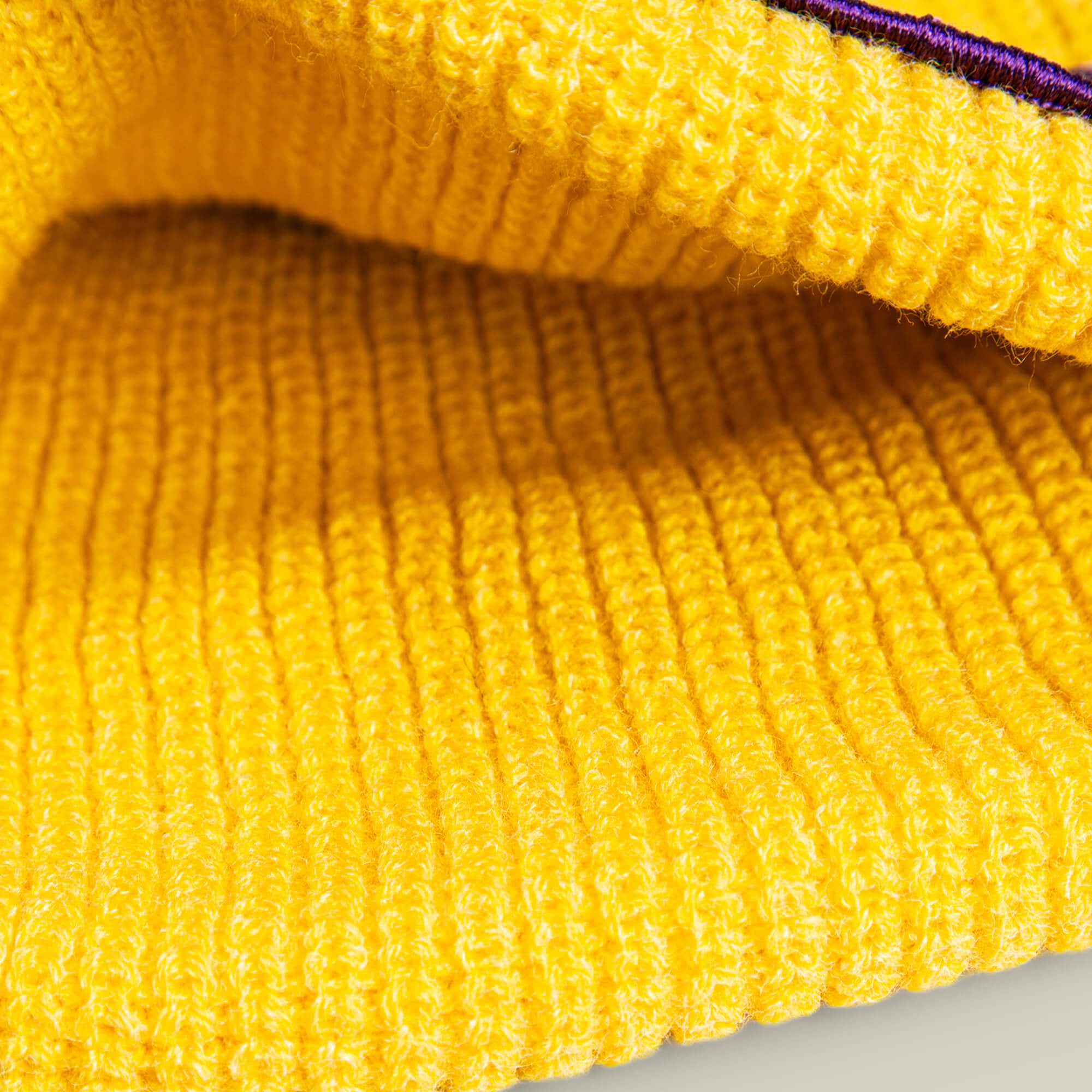 Close-up of the bright yellow ribbed knit fabric of The Mamba Beanie by Goorin Bros.