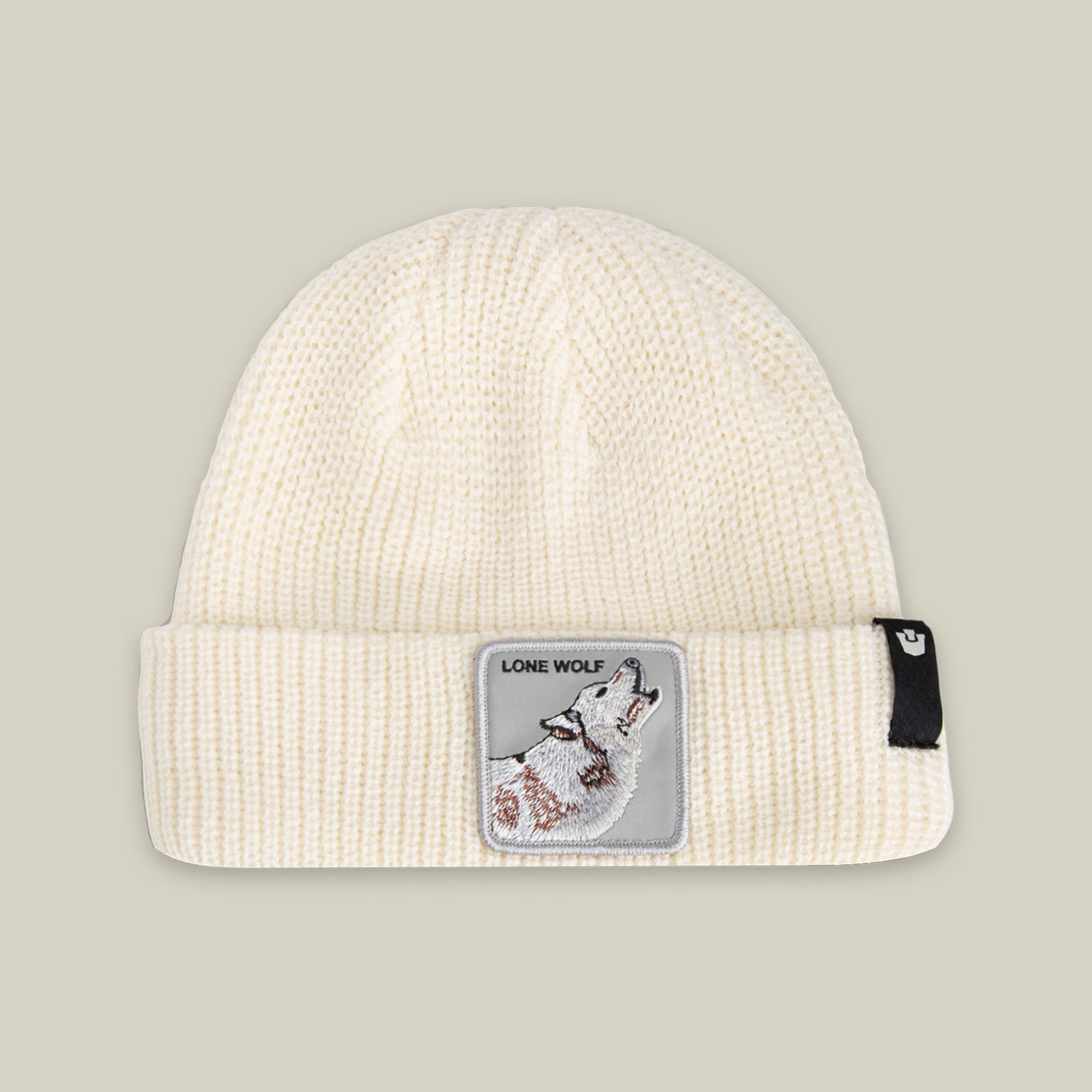 The Lone Wolf Beanie by Goorin Bros. is a DUST-colored winter hat with a howling wolf patch reading "LONE WOLF" and a small black tag on the cuff.