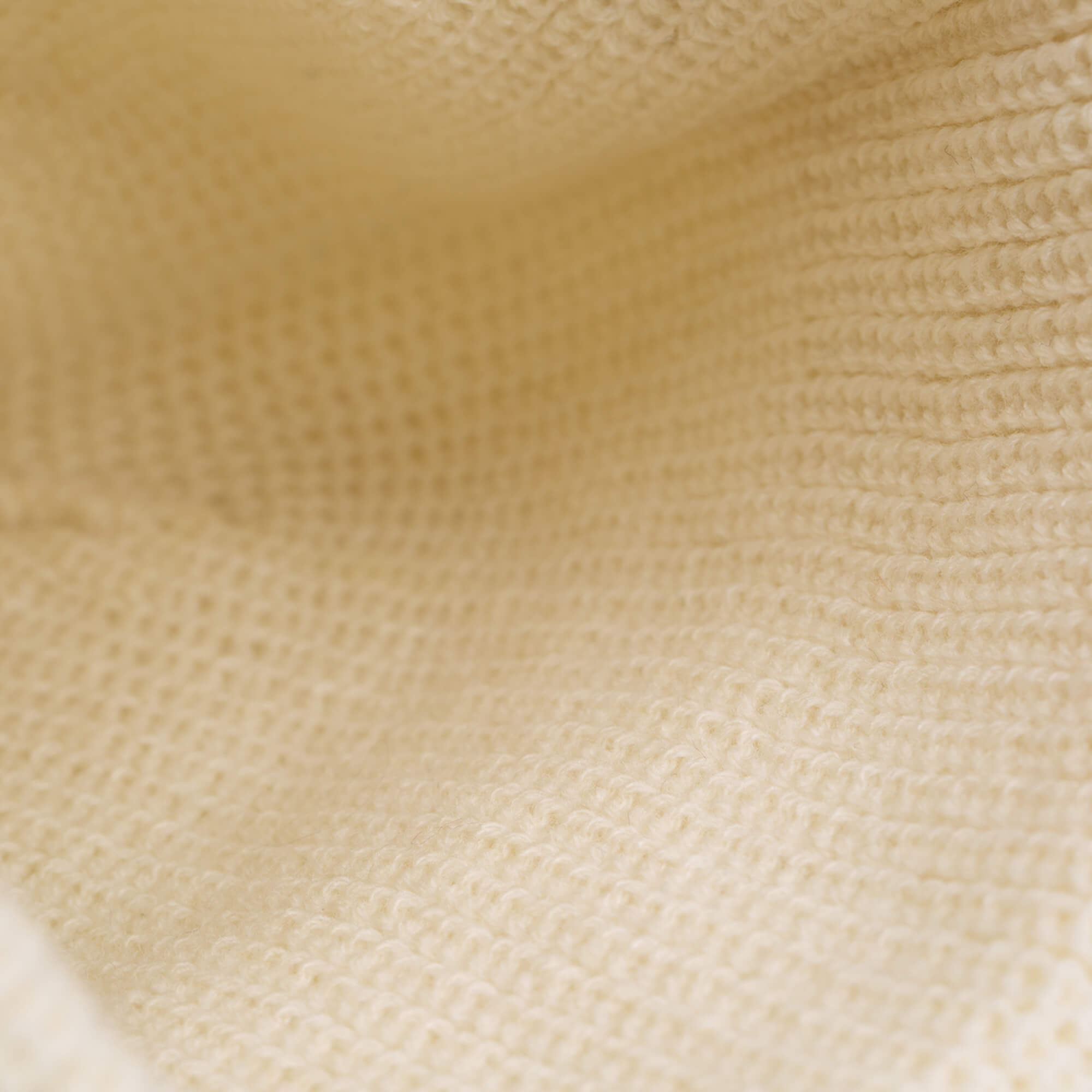 Close-up of cream-colored knitted fabric highlighting its soft texture and pattern—ideal for The Wise Ass Beanie by Goorin Bros.