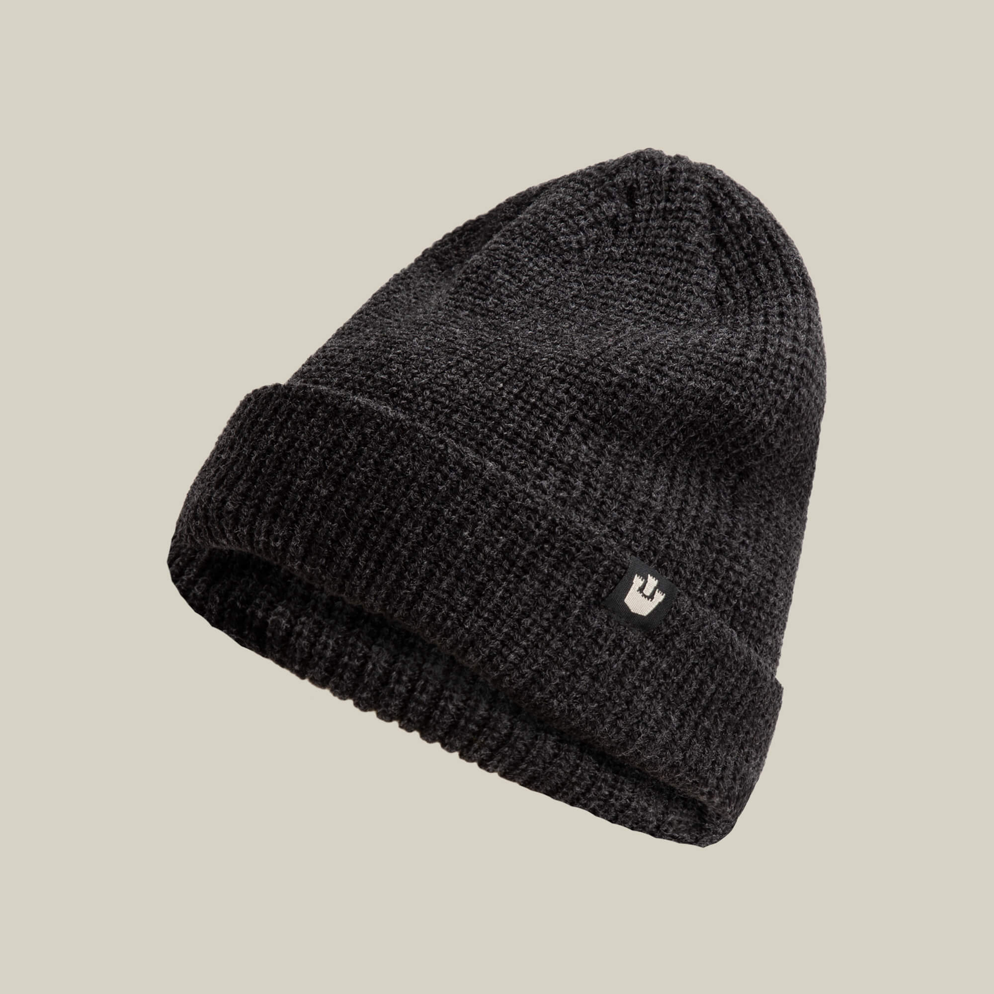 The Goorin Bros. Air to Fakie is a black Watchman beanie with a folded brim and small front logo patch, made from lightweight poly knit for all-season comfort, shown against a plain beige background.