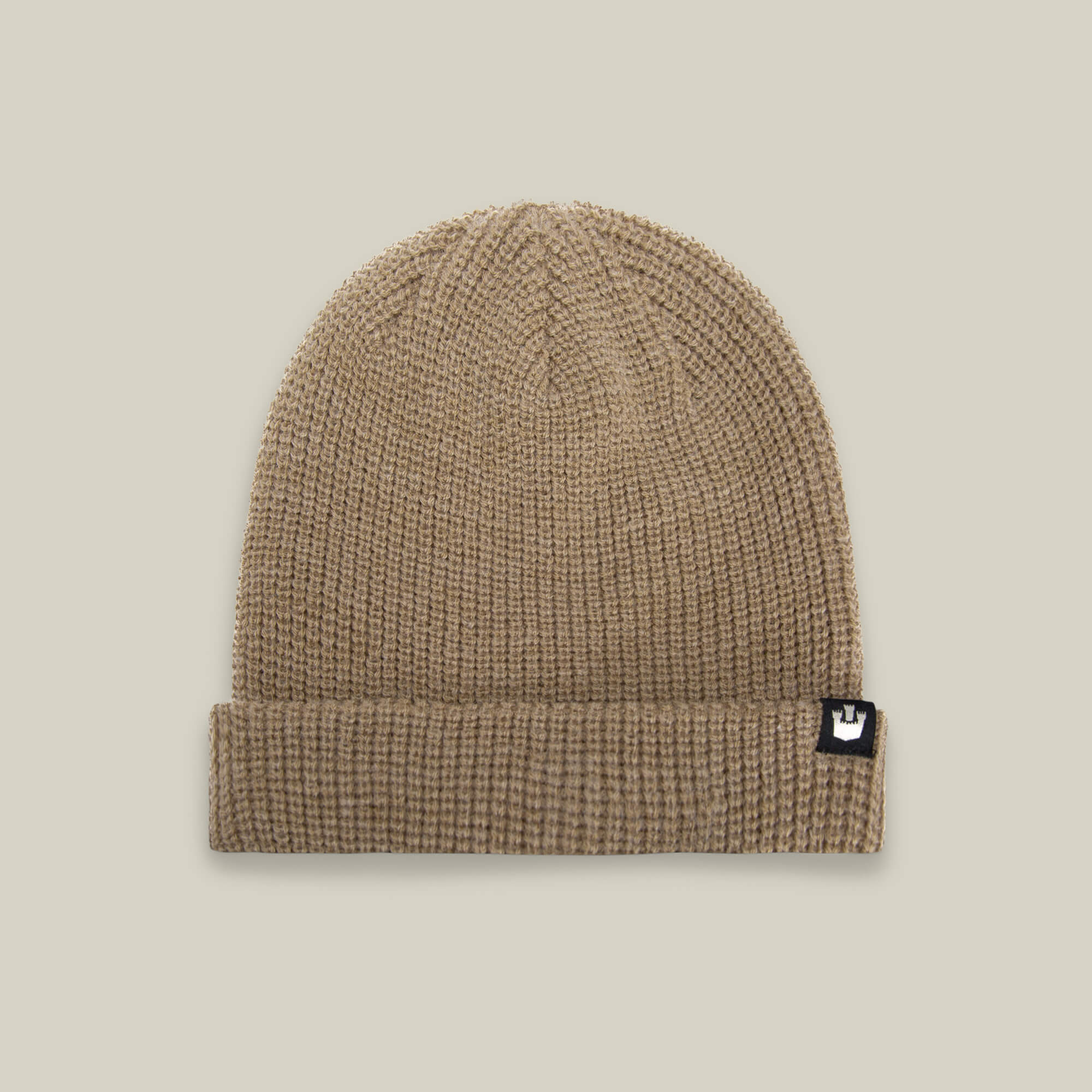 The Goorin Bros. Air to Fakie beanie in tan is an all-season hat, made from lightweight poly knit with a folded brim and a small black and white logo tag on the front.