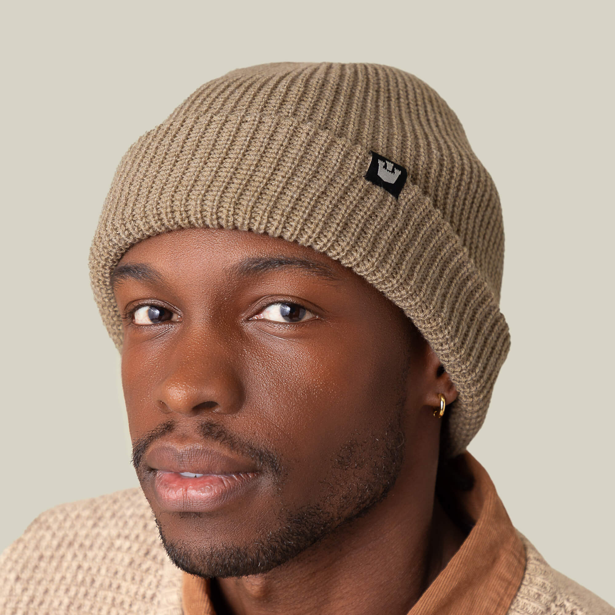 A man wearing the Goorin Bros. Air to Fakie beanie and a textured sweater looks at the camera against a plain light background.
