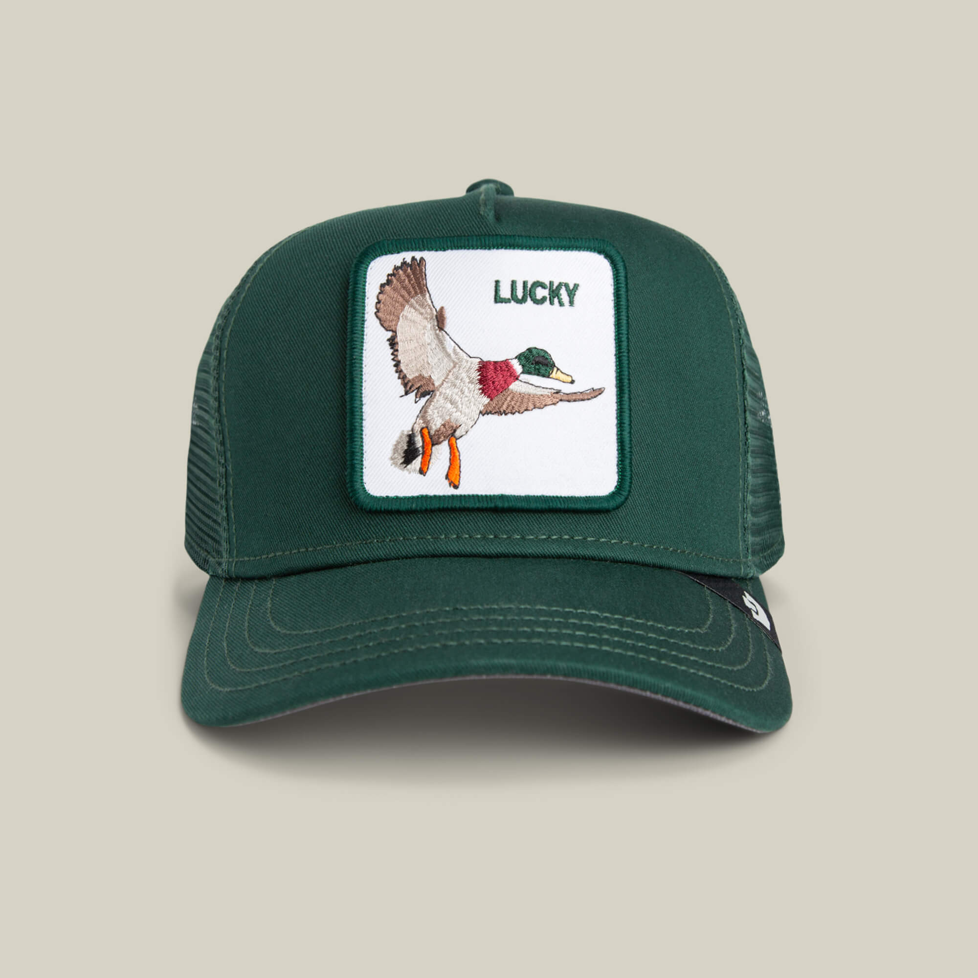 The Goorin Bros. Lucky Duck Mini is a kid-sized green trucker hat with a mesh back, white front featuring a flying duck patch and "LUCKY" embroidery, finished with a classic green crown.