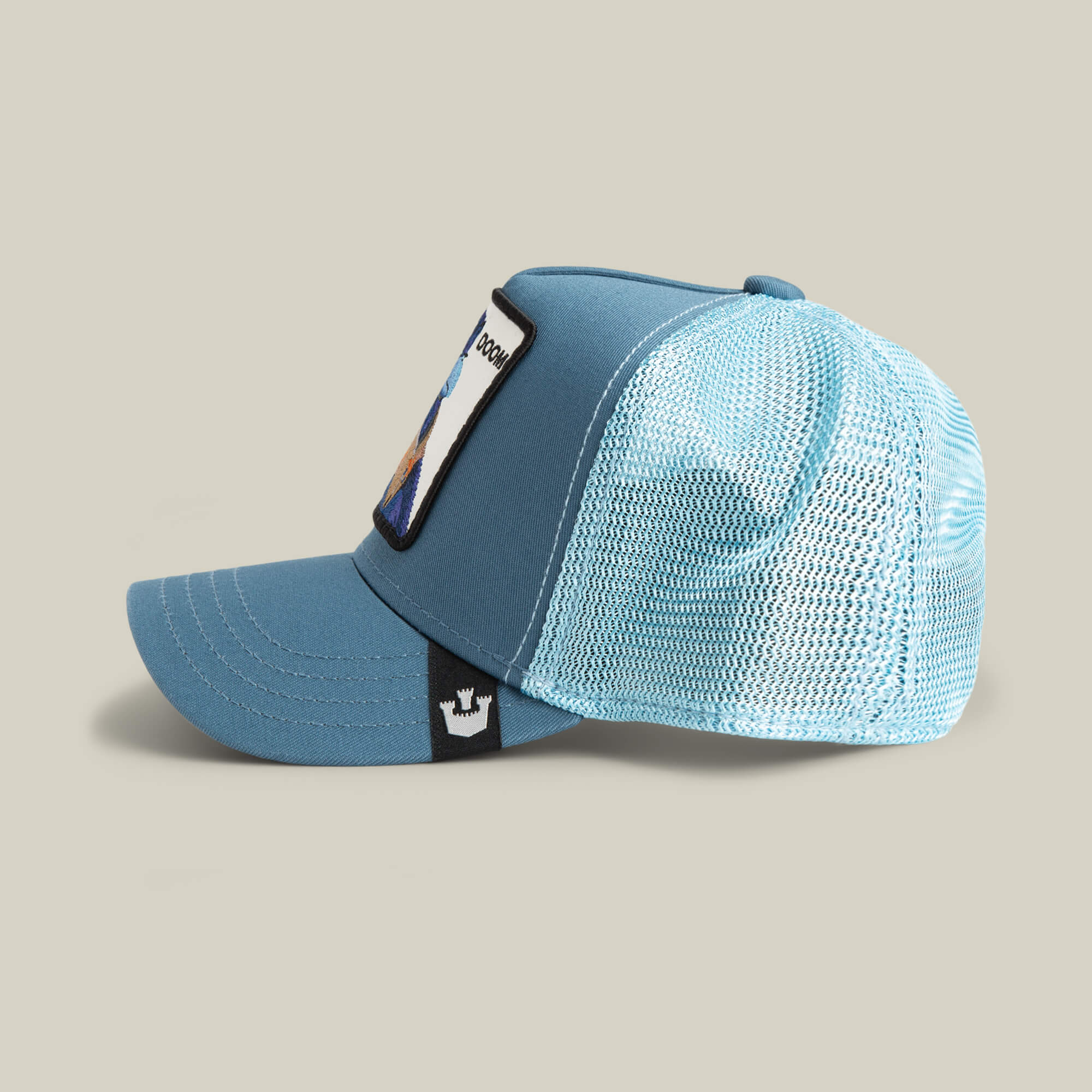 The BG2 - Doom (KIDS) by Goorin Bros. is a light blue trucker hat with a mesh back, flat brim, and a rectangular front patch—ideal for catching big air. Shown in side profile on a plain background.