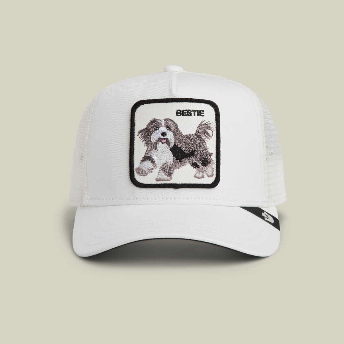 The Goorin Bros. Bestie Trucker Mini is a white mesh-back snapback hat featuring an embroidered Shih Tzu dog patch on the front, displayed against a neutral background.