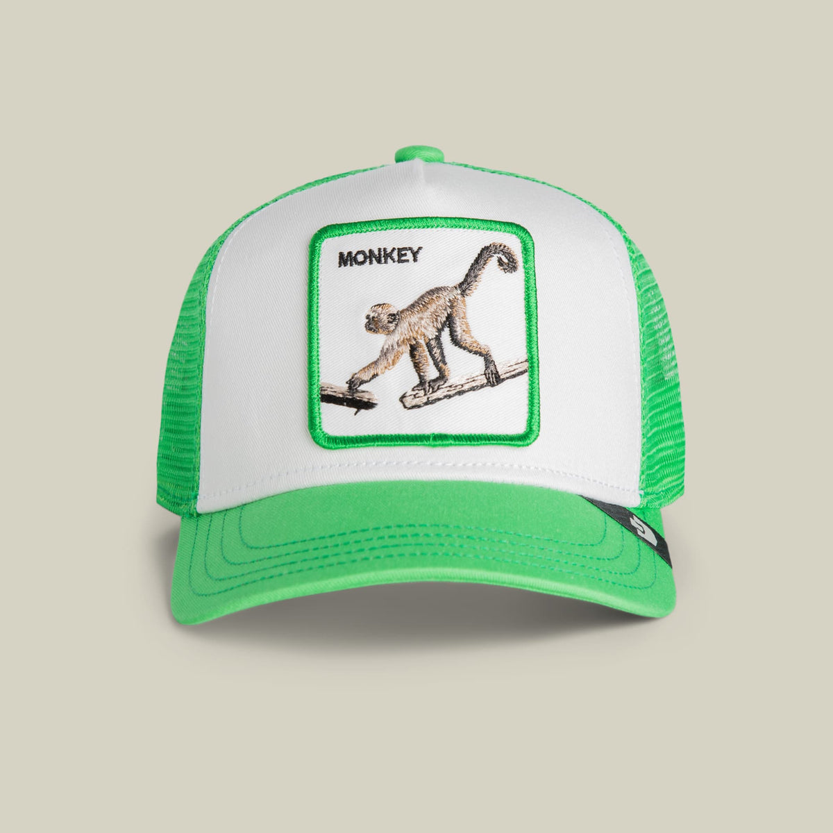 The Goorin Bros. Monkey Mini trucker hat features a green and white mesh design with an embroidered monkey patch on the front panel against a neutral studio background.