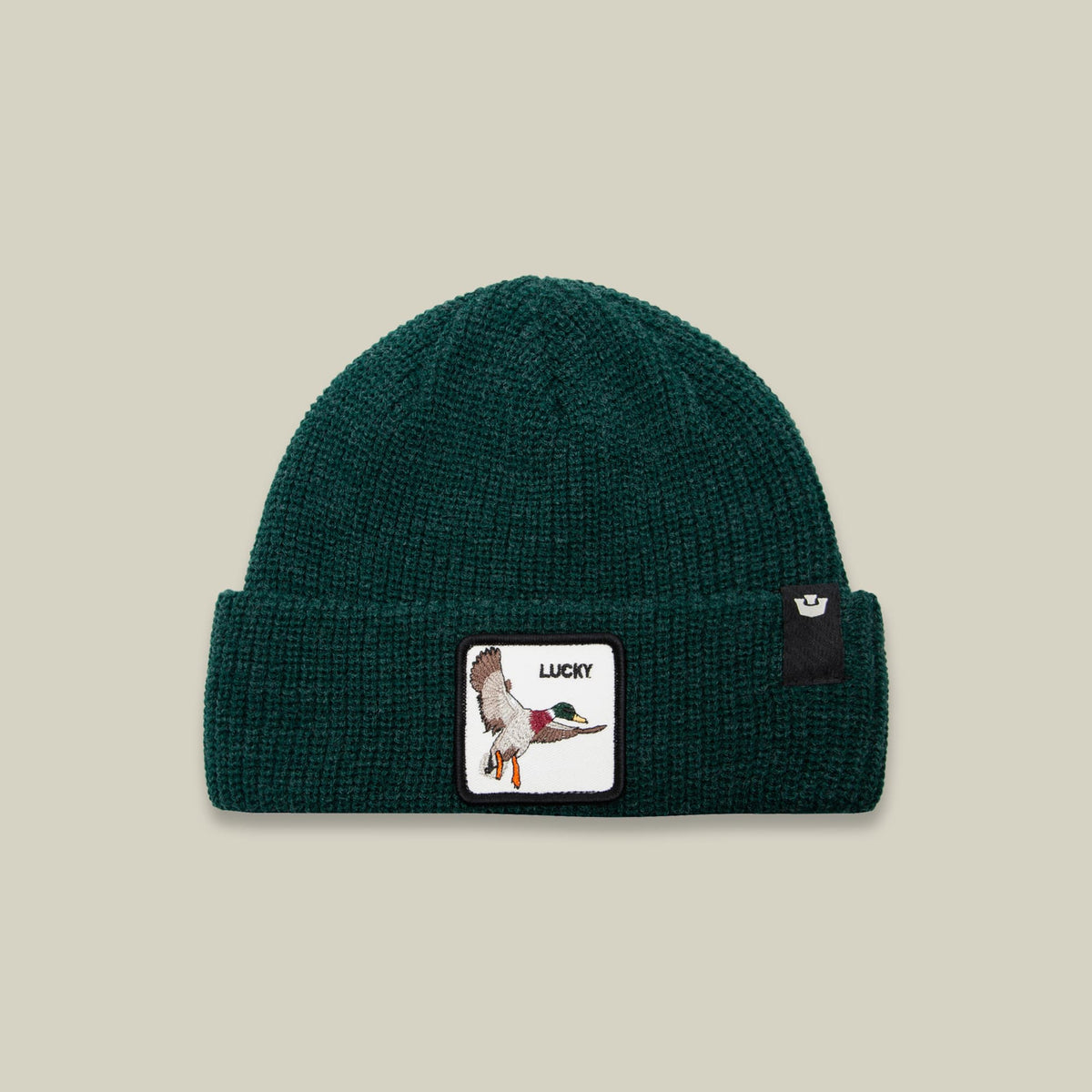 The Lucky Beanie Mini by Goorin Bros is a teal green ribbed knit beanie featuring an embroidered duck patch with "Lucky" text on the front and a small brand logo on the side, displayed against a neutral studio background.