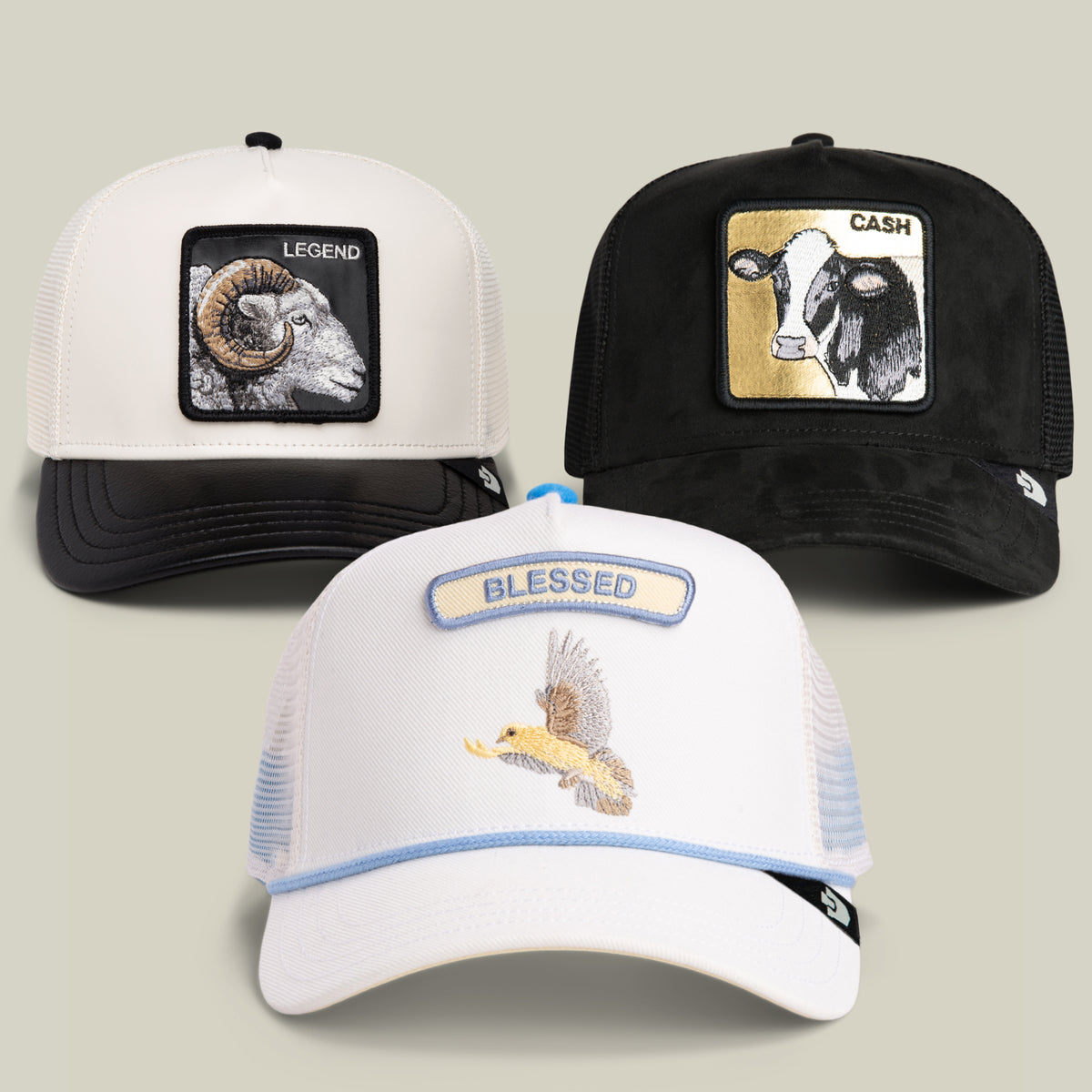 Introducing the 24 Hours of Labor Bundle from Goorin Bros.: three trucker hats featuring unique embroidered patches—a ram with LEGEND, a cow with CASH, and a front hat with an eagle and BLESSED. Each hat comes with a mesh back for comfort, offering the perfect way to add personal flair or a playful twist to your everyday style.