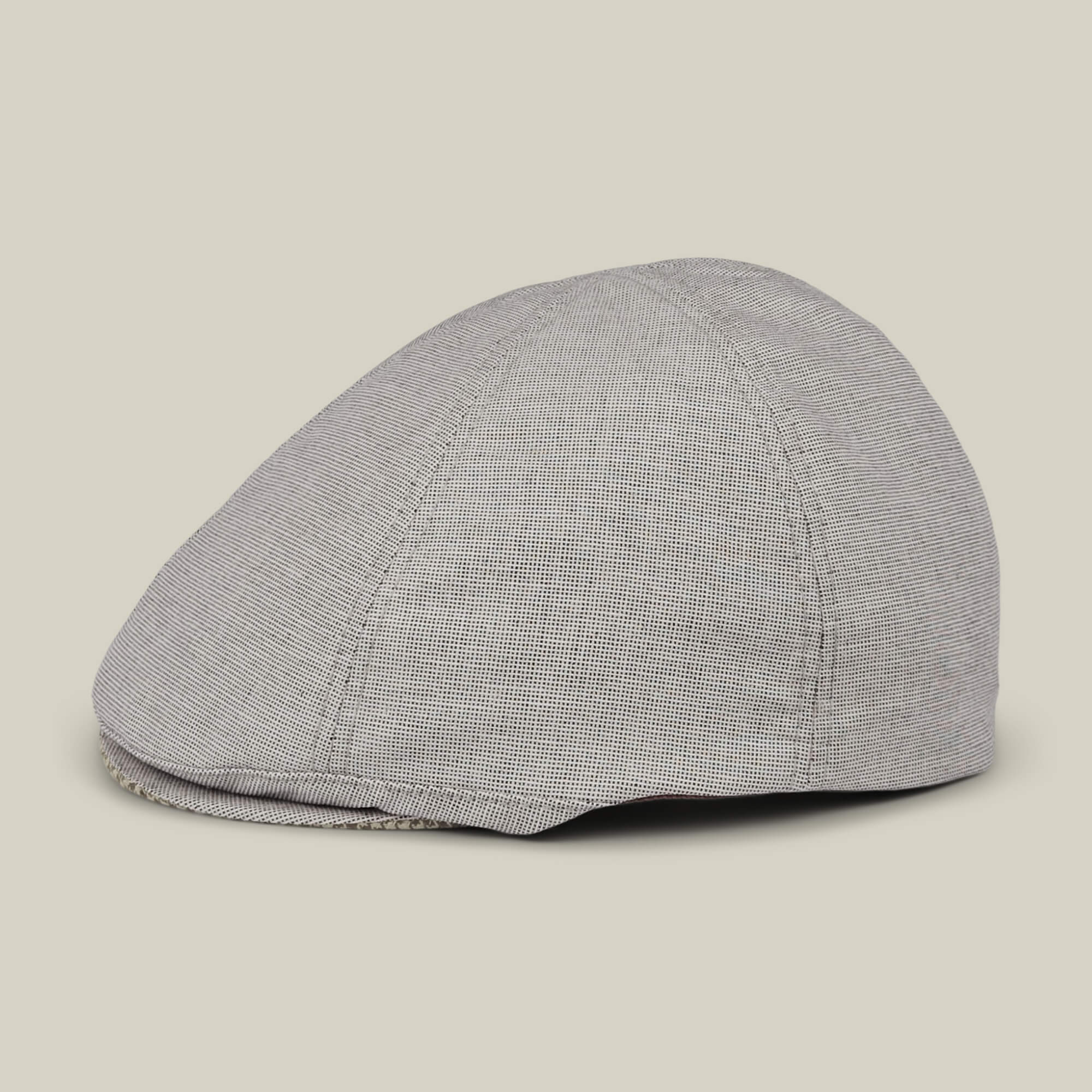 The Goorin Bros. Mile Rock is a gray 6-panel Ivy flat cap with a subtle checkered pattern, hand cut and sewn, shown from the side on a plain beige background.