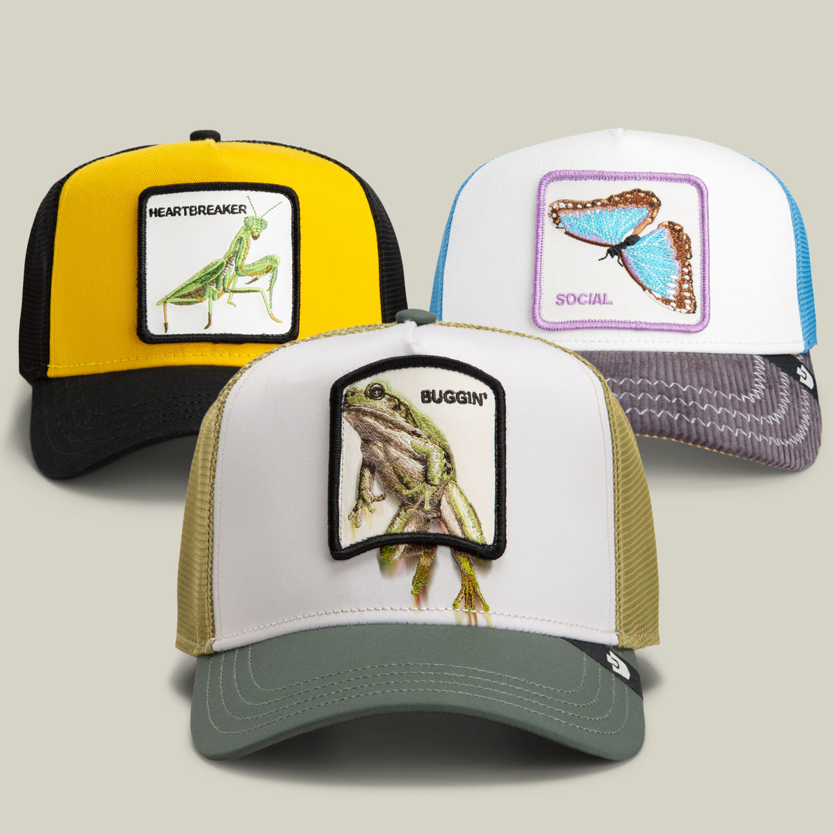 The Buggin’ Out Bundle by Goorin Bros. features three playful trucker hats, each with a unique color scheme and an embroidered animal patch: a frog labeled “BUGGIN,” a praying mantis labeled “HEARTBREAKER,” and a blue butterfly labeled “SOCIAL.” These hats showcase bug-themed designs with a whimsical, friendly vibe.